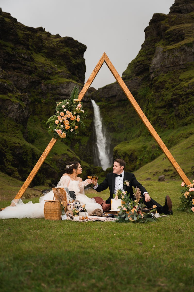 elopement picnic at Icelandic waterfall with geometric wedding photo backdrop