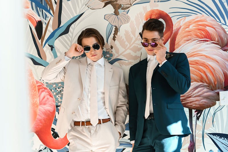 Light tan and deep teal suits for homecoming 2022 with cool sunglasses.