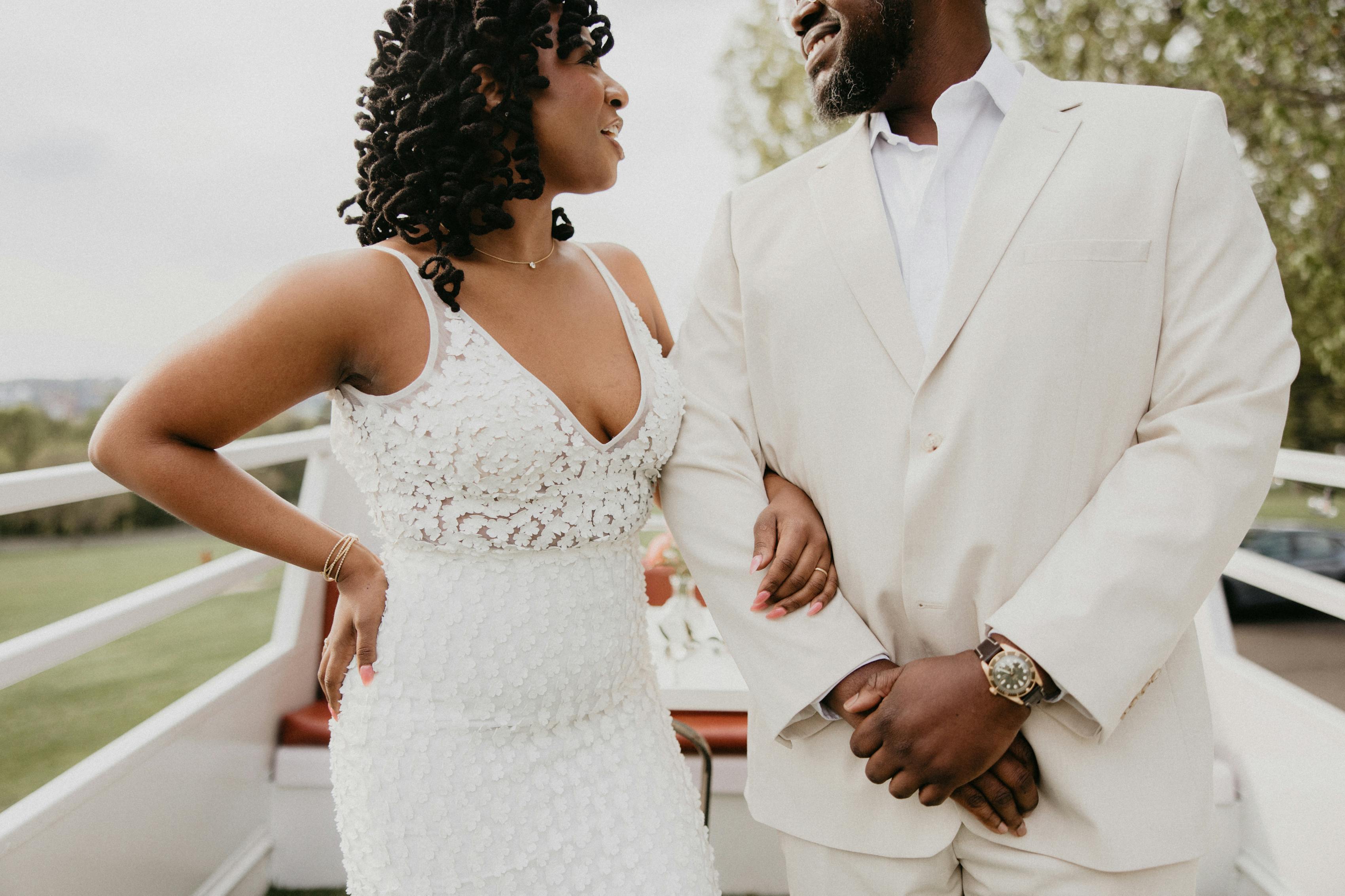 Tan wedding suit style displayed on cool groom at relaxed small outdoor wedding smiling at bride