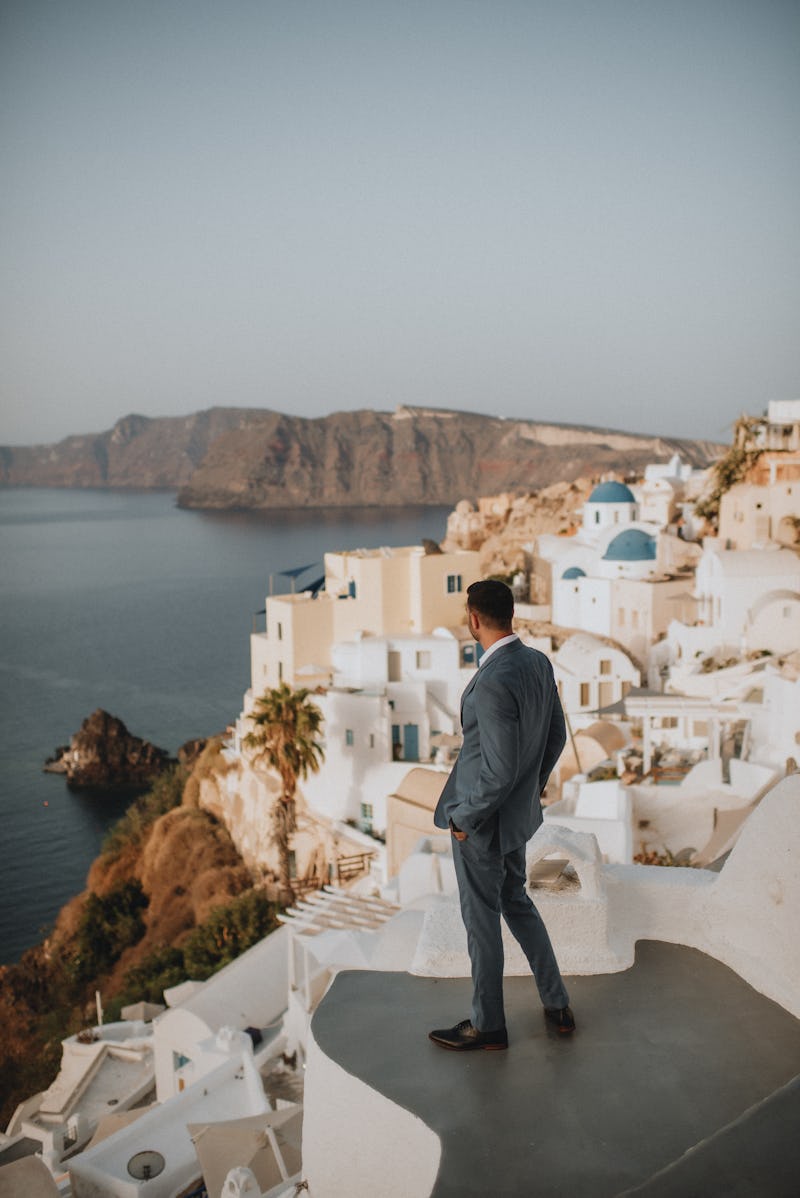 Groom in Light Blue Suit on the Santorini Coast at Destination Wedding