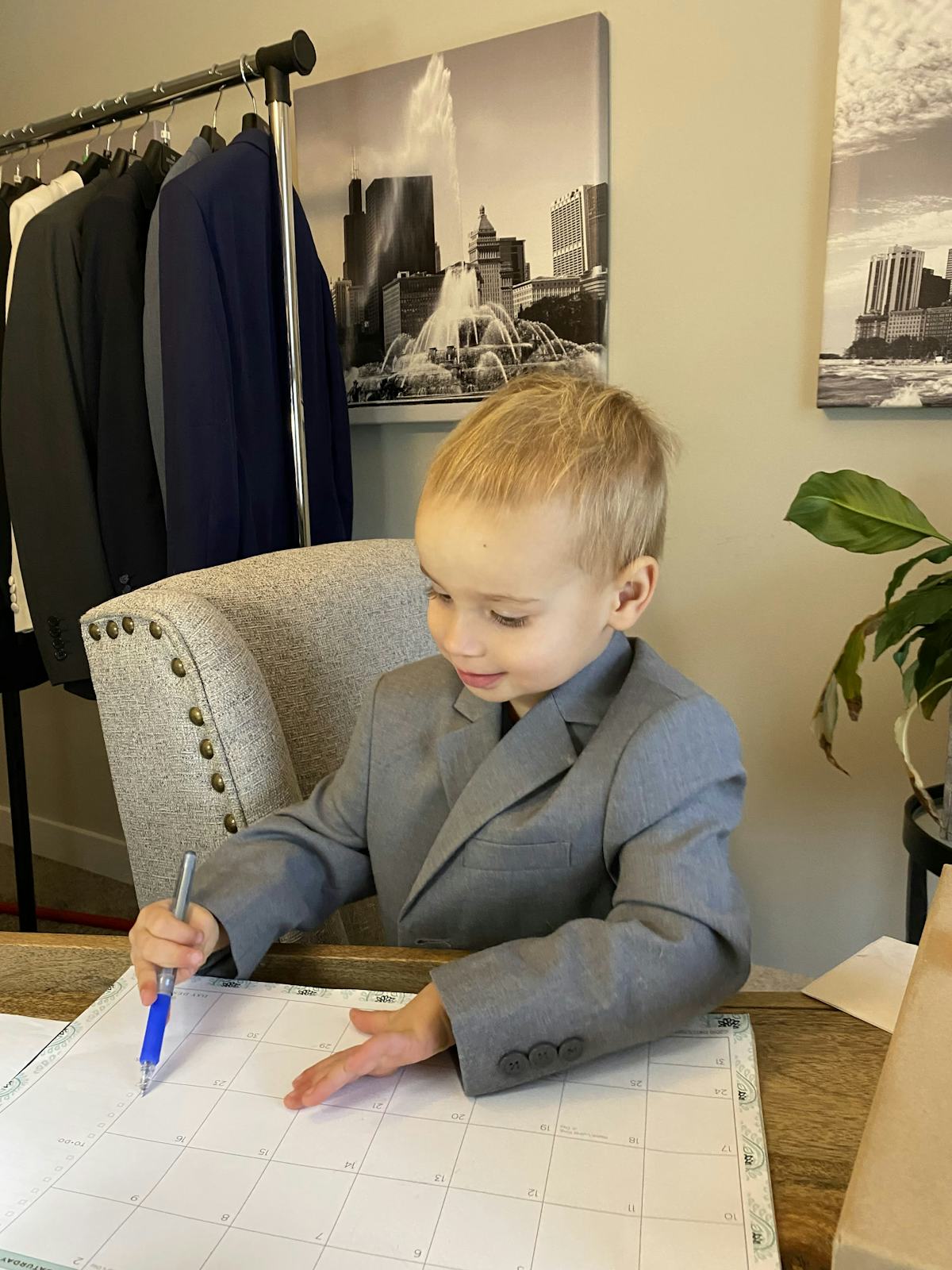 2.5-year-old Theo hard at work at mom's desk in SuitShop's Light Grey Boy's Suit