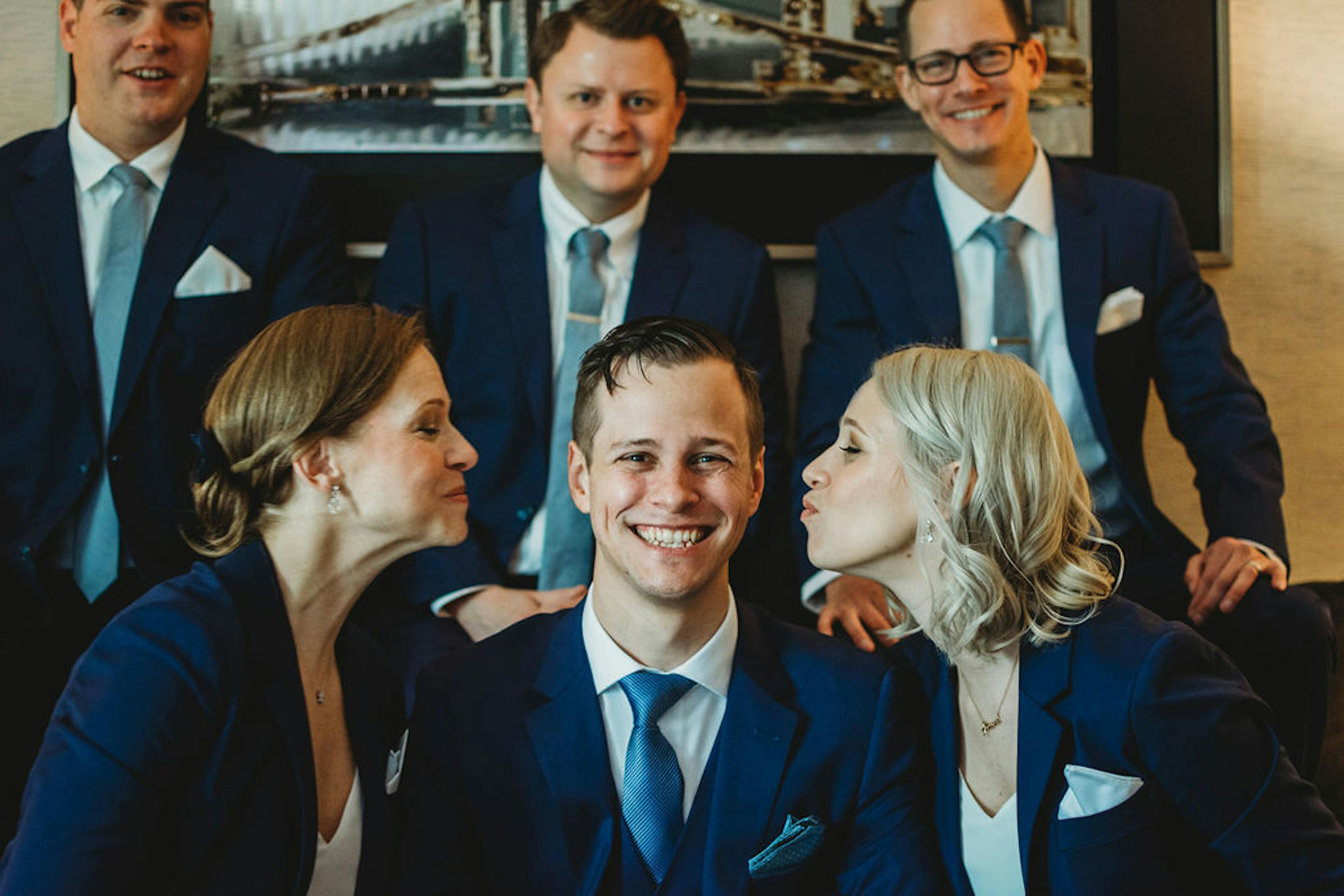 a grooms and his groomshumans in brilliant blue suits