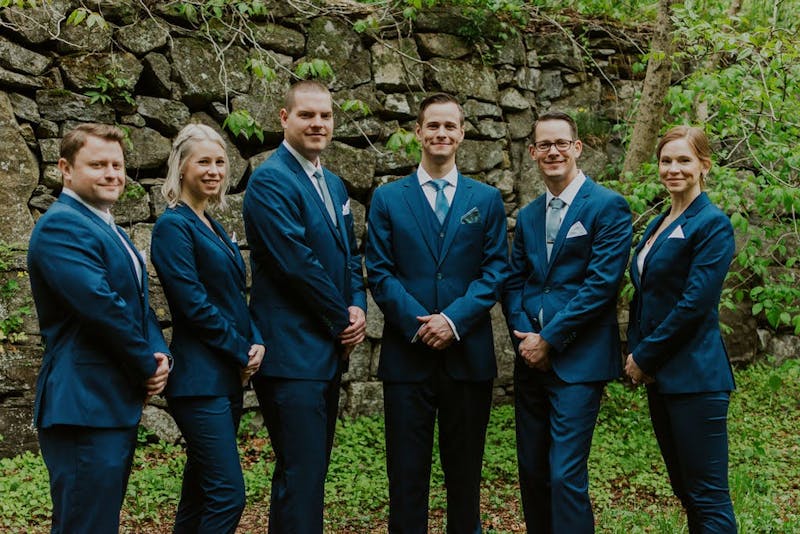 Mixed gender wedding party with groomswomen and groomsmen wearing teal suits for men and teal suits for women
