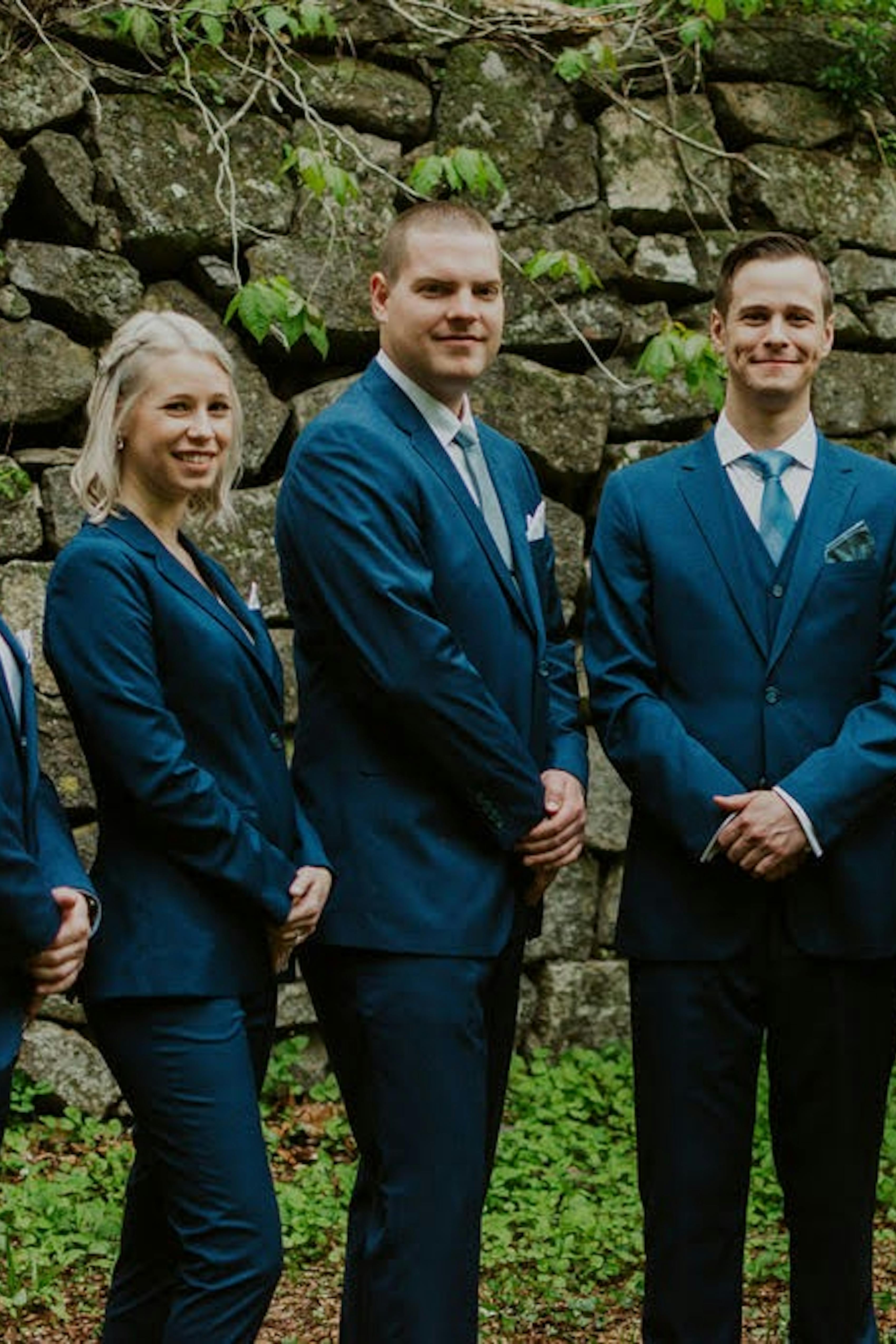 Mixed gender wedding party with groomswomen and groomsmen wearing teal suits for men and teal suits for women