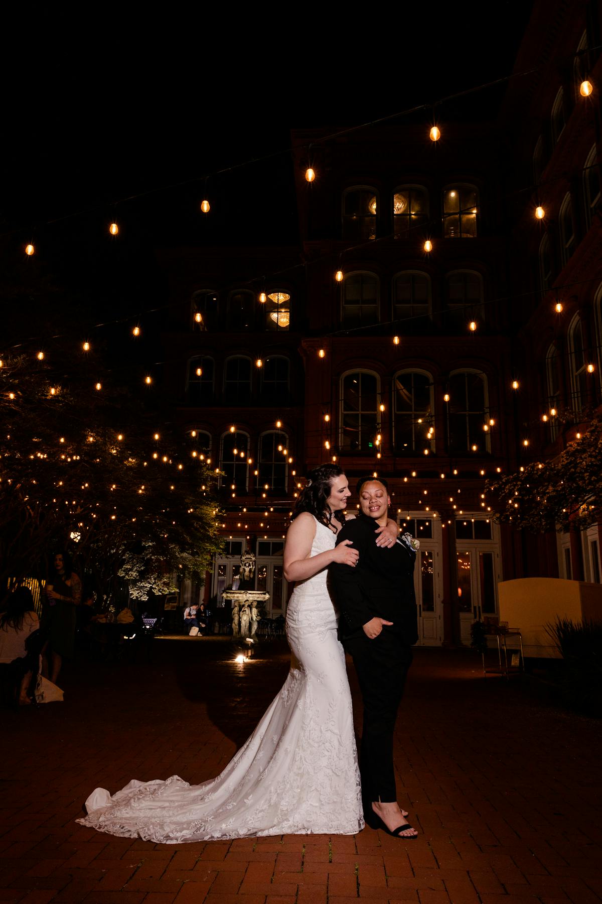 Two brides hugging on their wedding reception dance floor at The Big Fake Wedding Baltimore.