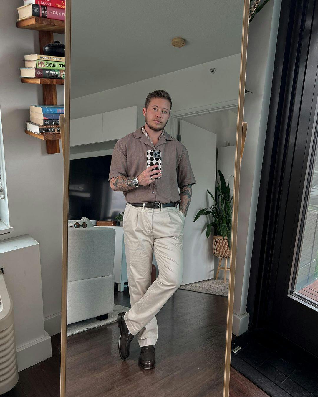 Trendy and classic professional monochrome outfit with tan dress pants, brown loafers, brown belt, and beige knit short sleeve shirt for a men's work outfit.