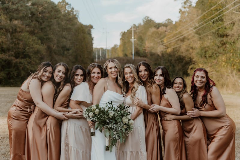 Champagne, rust, and copper bridesmaid dresses in bridal party..