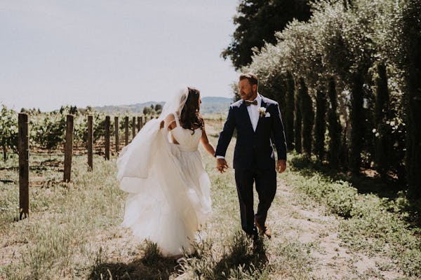 Trendy bride and groom in a vineyard making their own traditions without father of the bride at wedding.