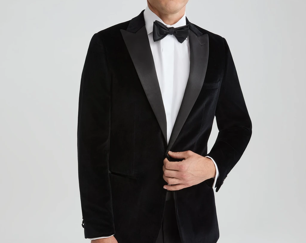 Black velvet tuxedo with satin lapels and black bow tie for a formal wedding or black tie event.