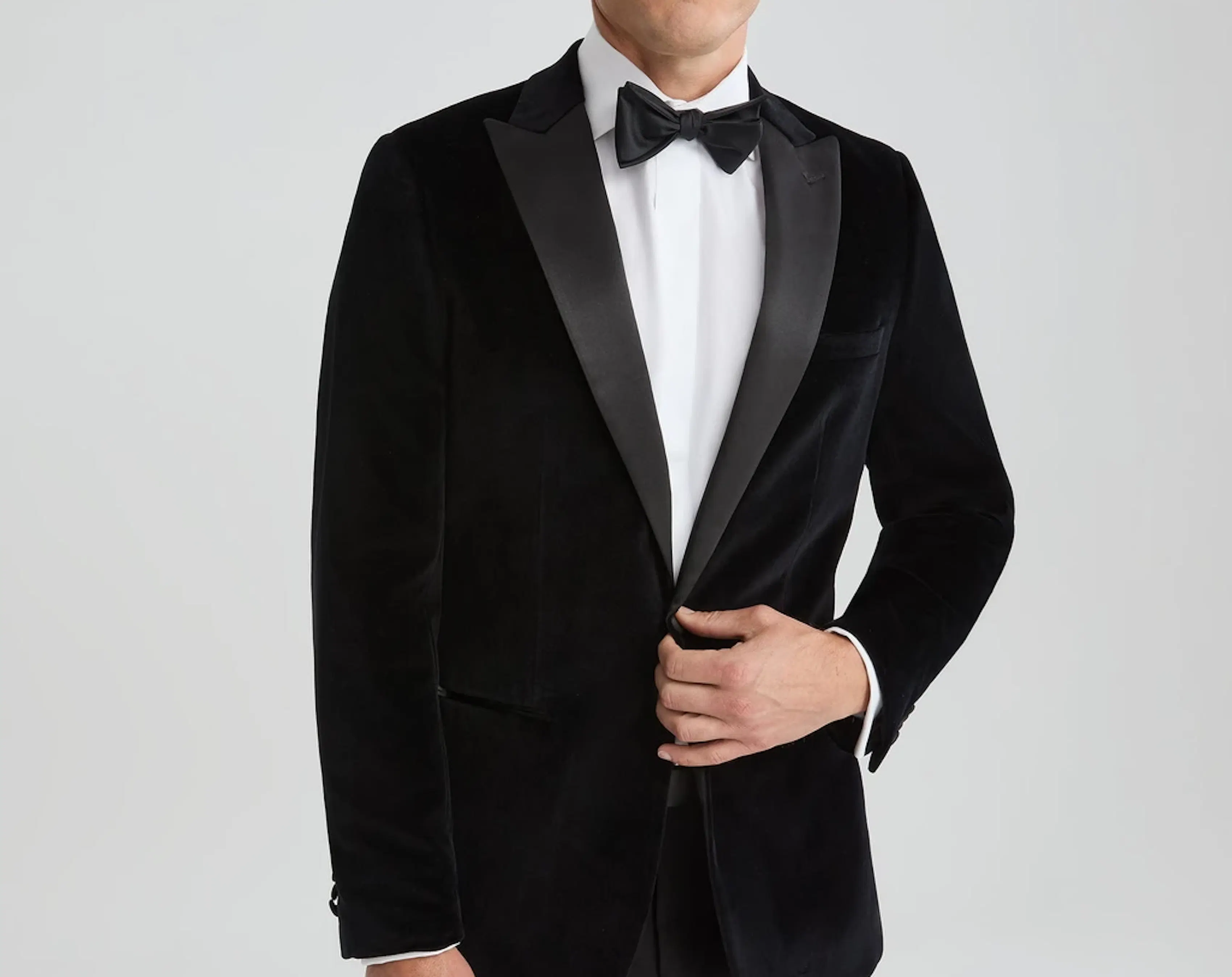 Black velvet tuxedo with satin lapels and black bow tie for a formal wedding or black tie event.