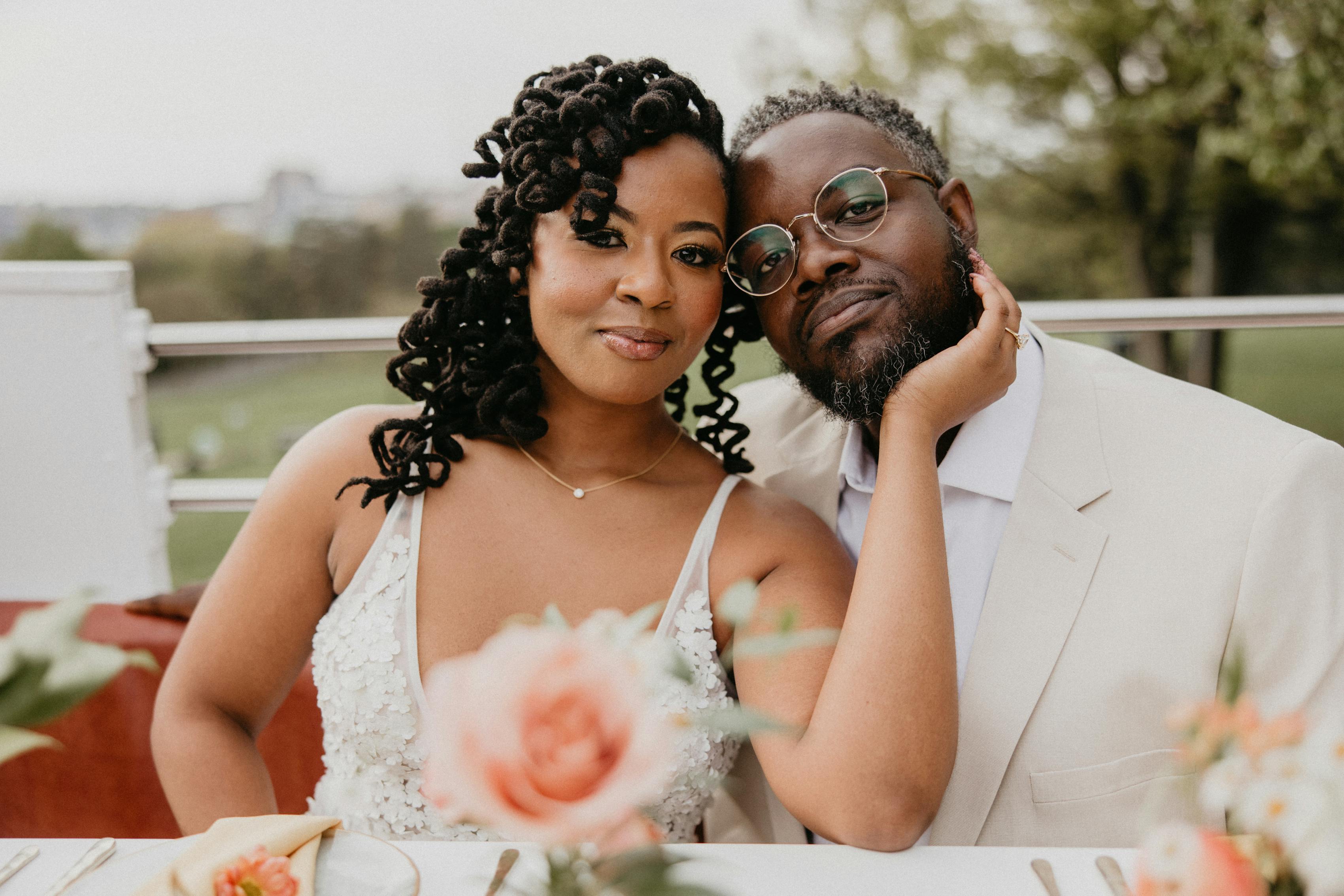 Modern minimalist style bride in floral applique dress and groom in tan suit at outdoor wedding