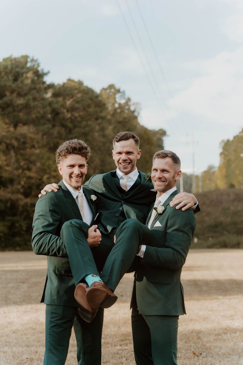 Groomsmen in hunter green suits for backyard wedding.