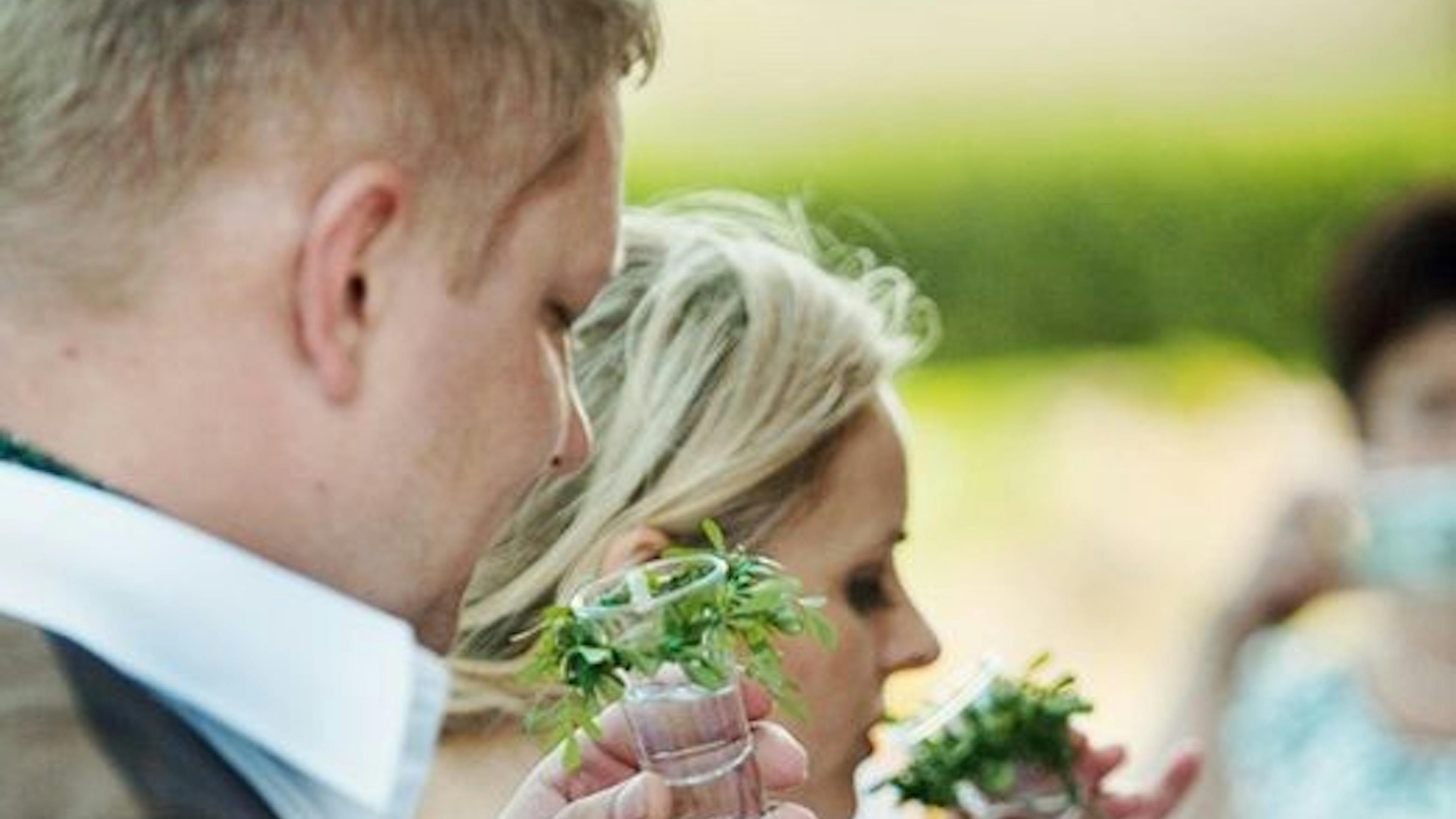 Rustic Lithuanian Wedding. Pictured: Couple practicing salt, bread, and vodka tradition.