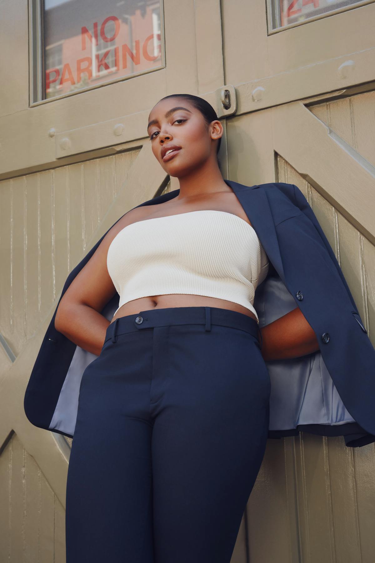 Woman confidently posing in New York City street wearing a navy blue power suit.