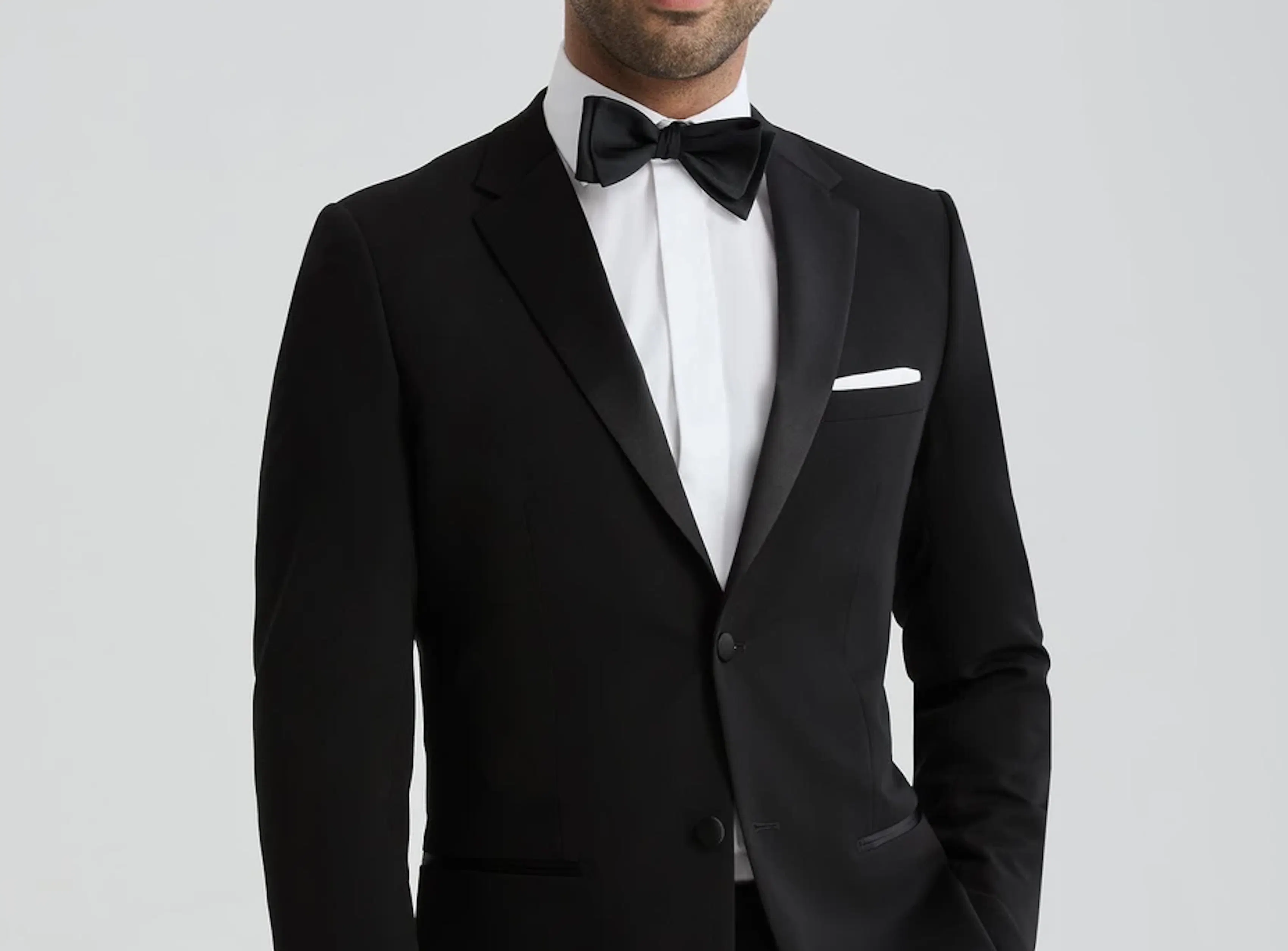 Black notch lapel tuxedo with bow tie and white pocket square for a formal wedding or event.