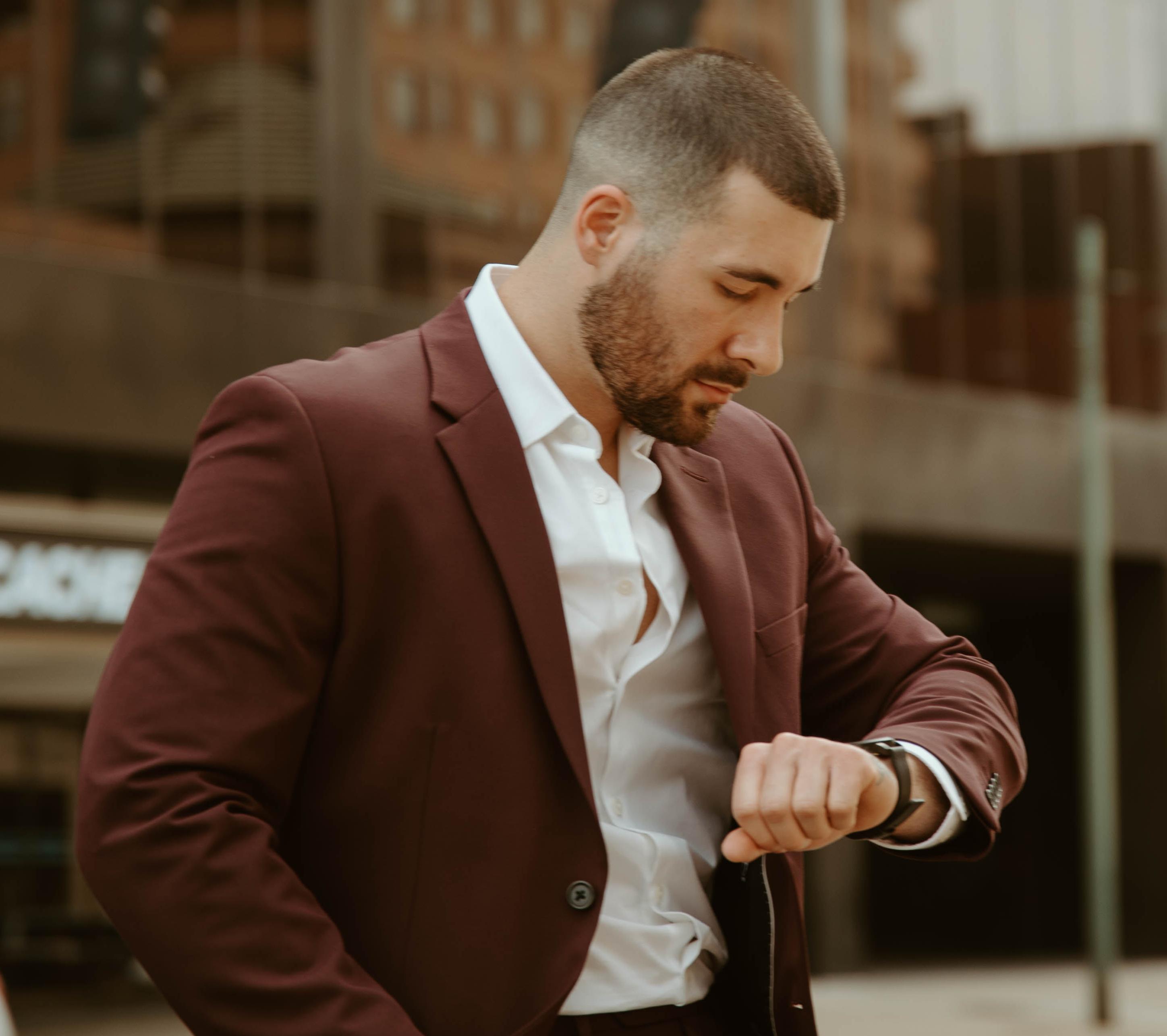 Man wearing a burgundy suit jacket and white shirt for a modern formal style.
