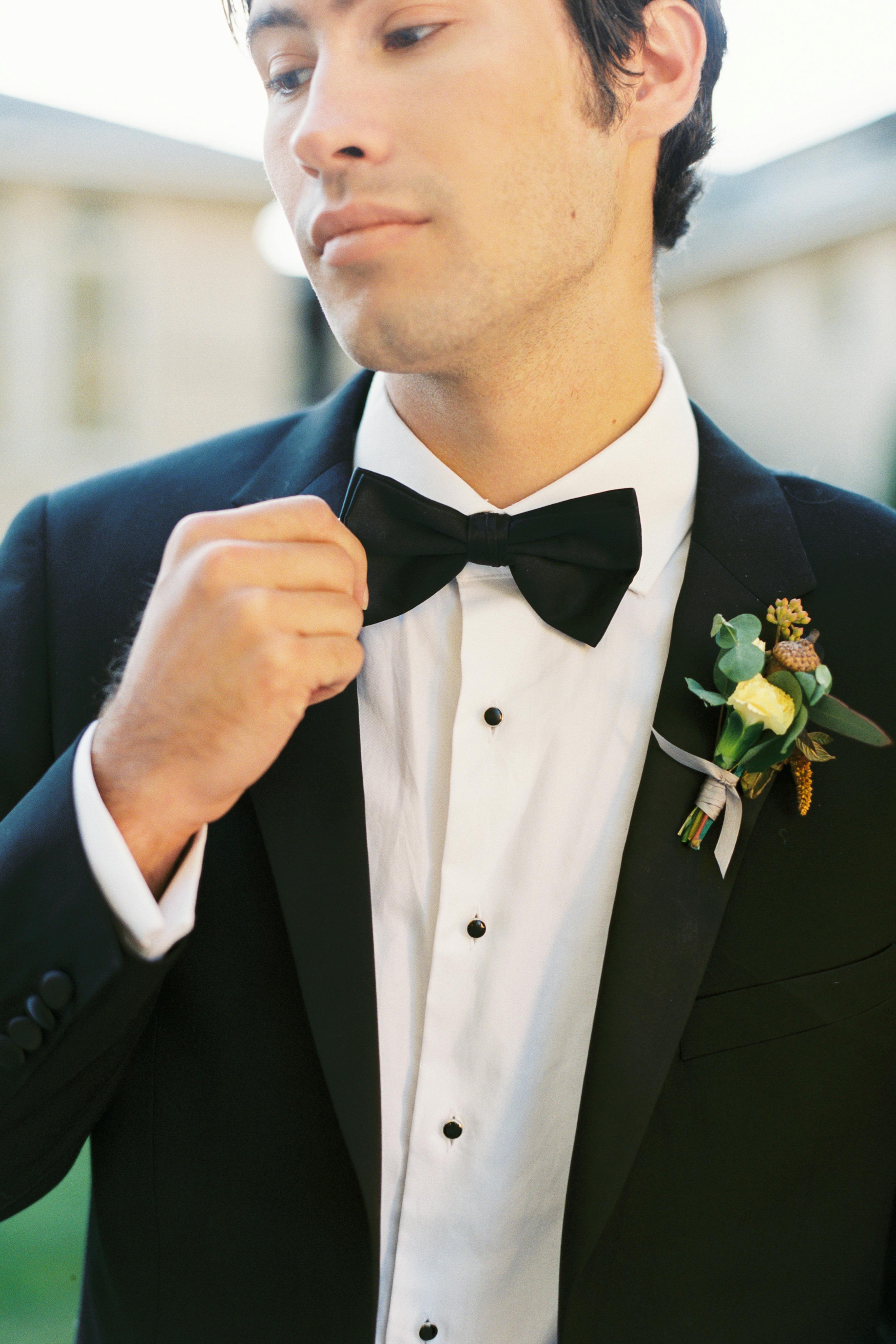Classic black tuxedo for prom with boutonniere and bow tie
