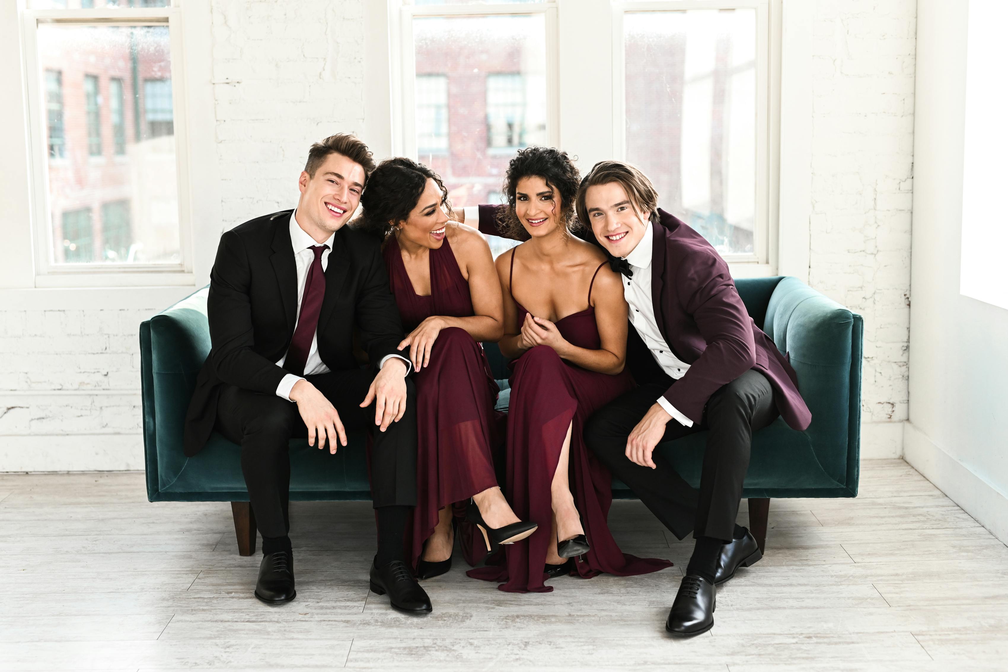 Prom group outfits with dates in black prom suit, burgundy prom tuxedo, and maroon dresses