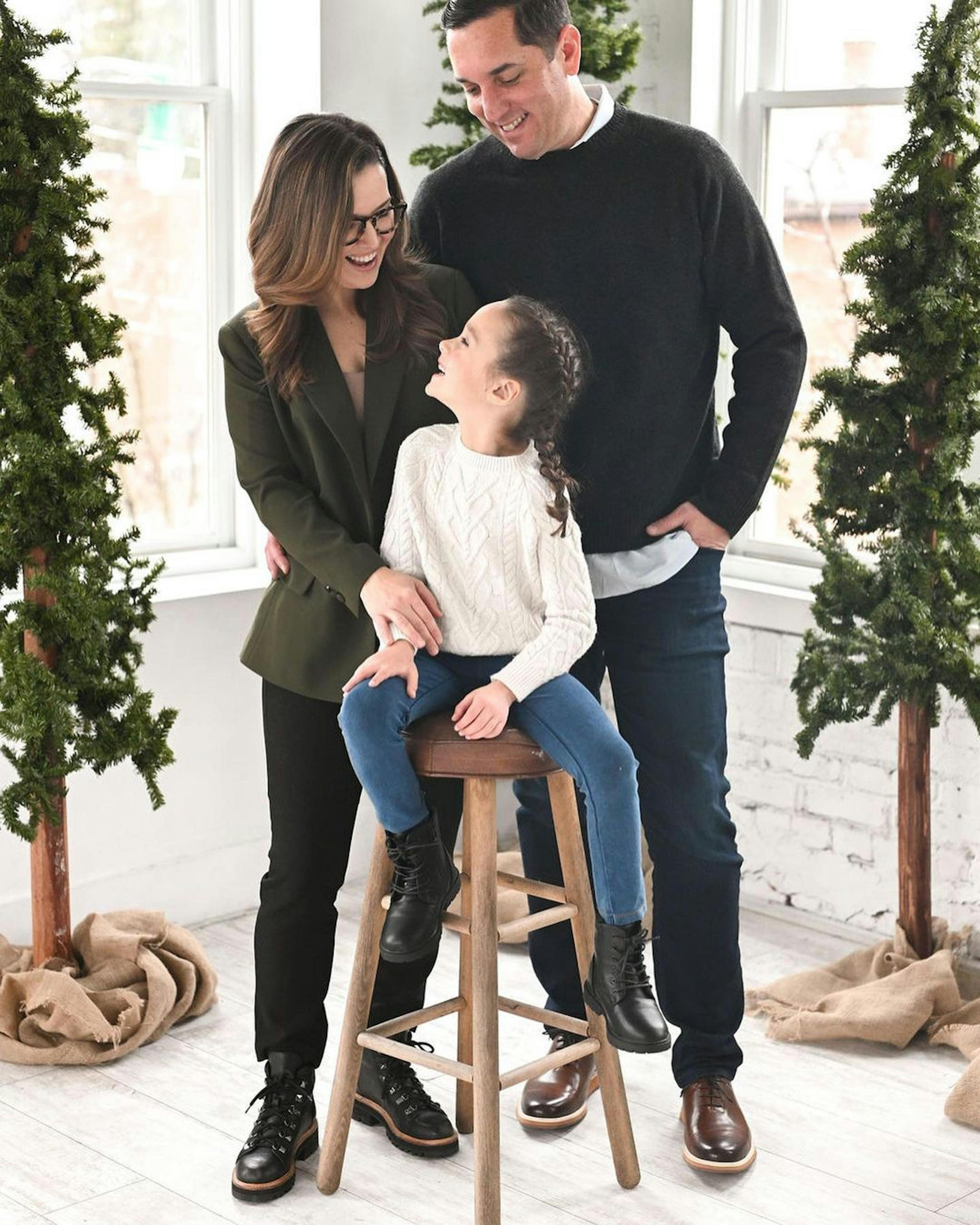 Family Christmas photo shoot outfit with olive green women's blazer, girl's sweater, and men's sweater