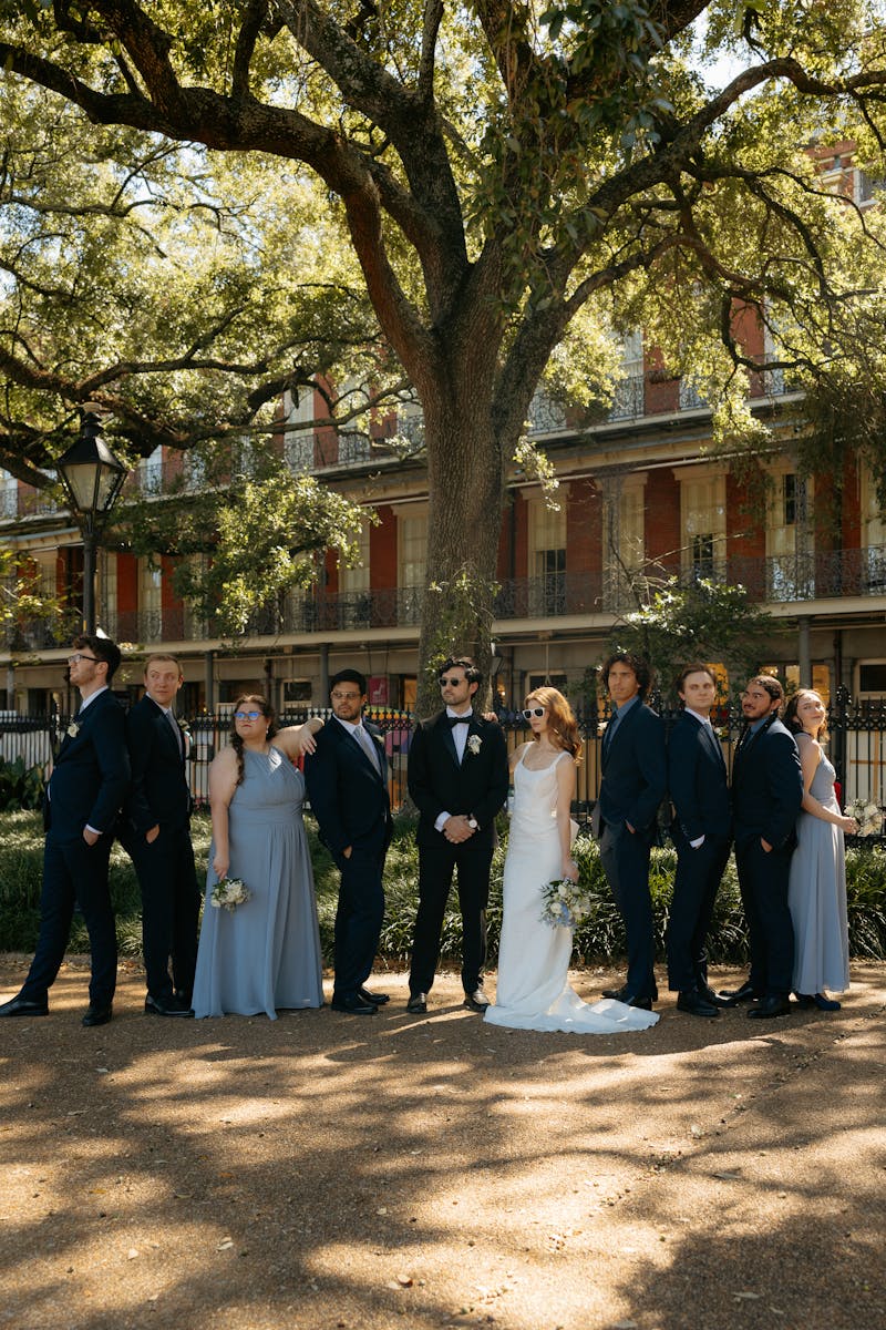 wedding party in navy blue suits and dusty blue bridesmaids dresses