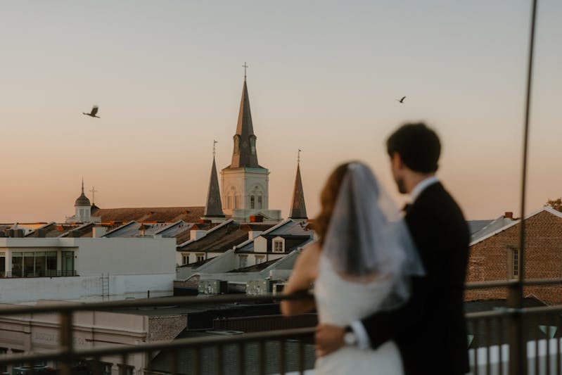 sunset shot of bride and groom on a rooftop overlooking new orleans