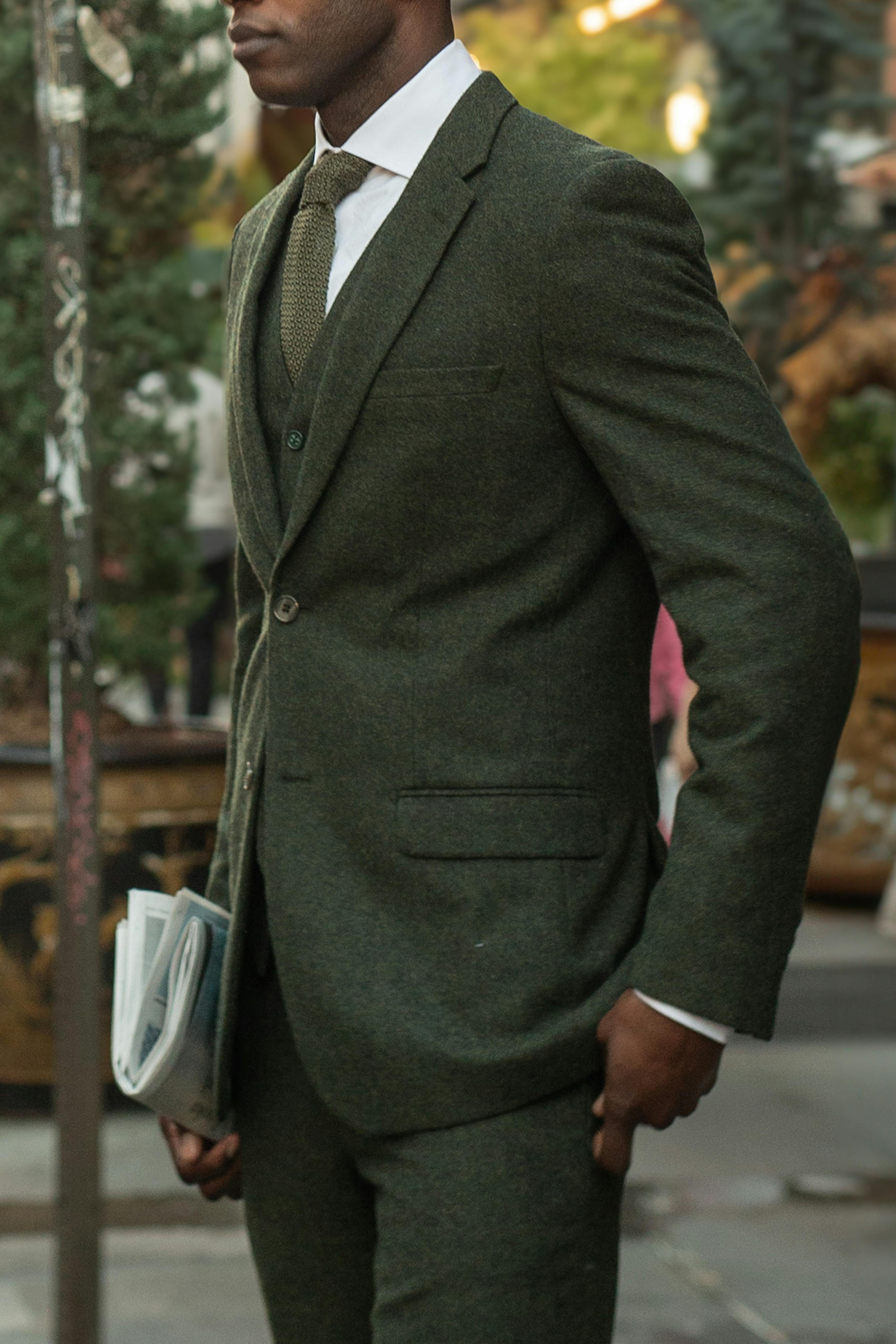 Men's office holiday or Christmas party outfit in dark green suit with monochrome accessories