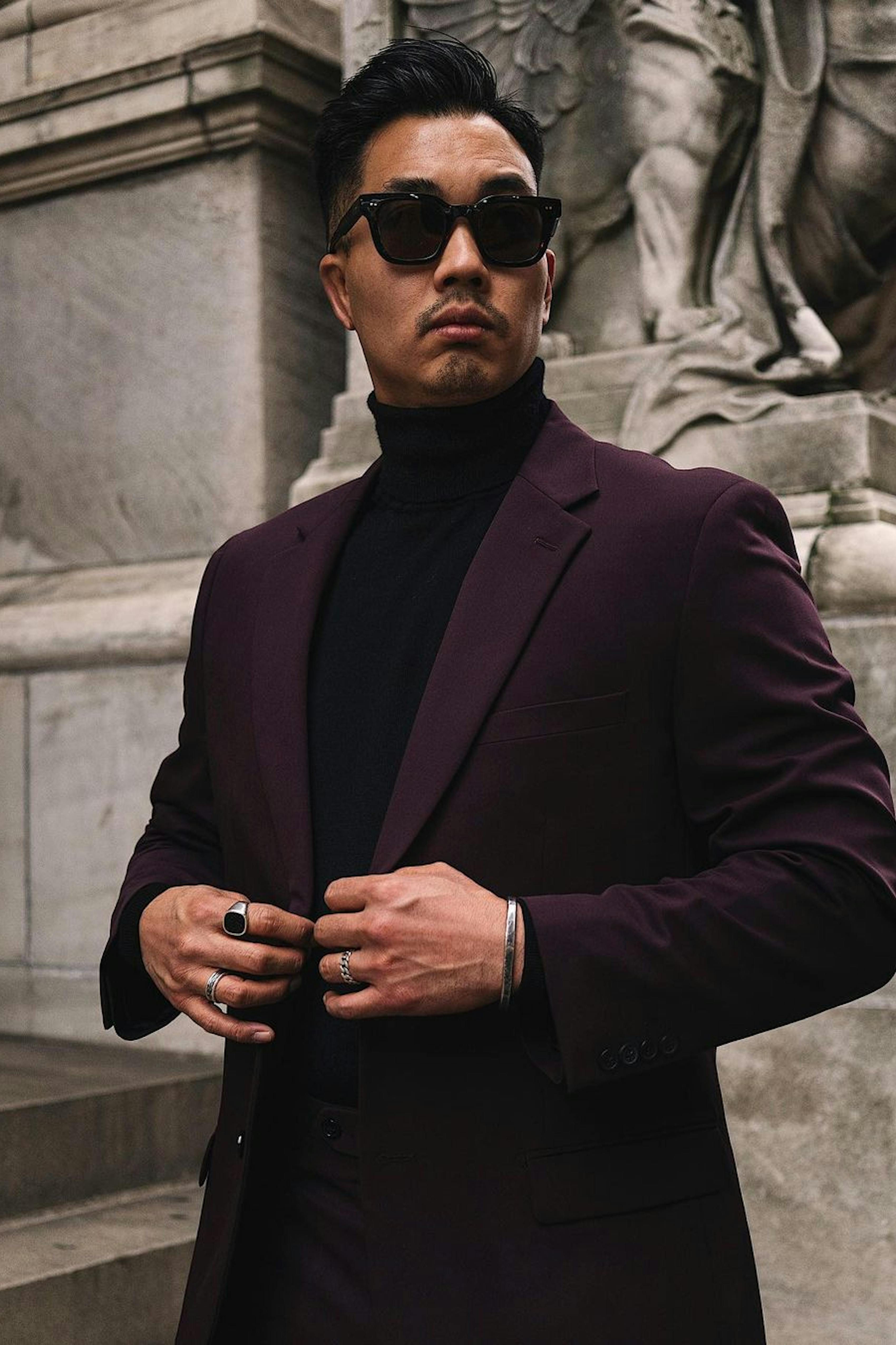 Man heading to winter wedding wearing cocktail attire with burgundy suit and turtleneck