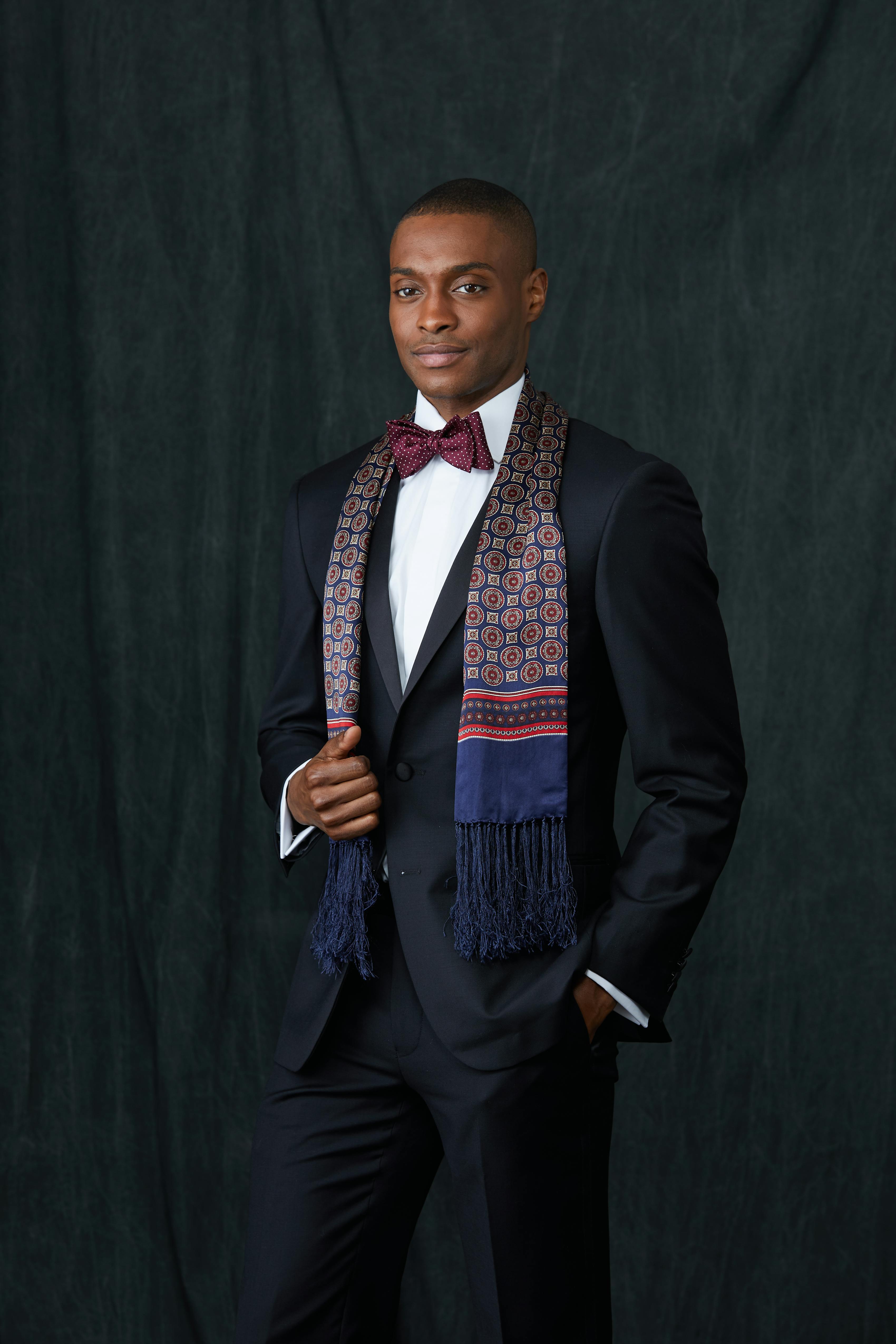 Man dressed for black tie wedding in winter with tuxedo, formal scarf, and burgundy bow tie