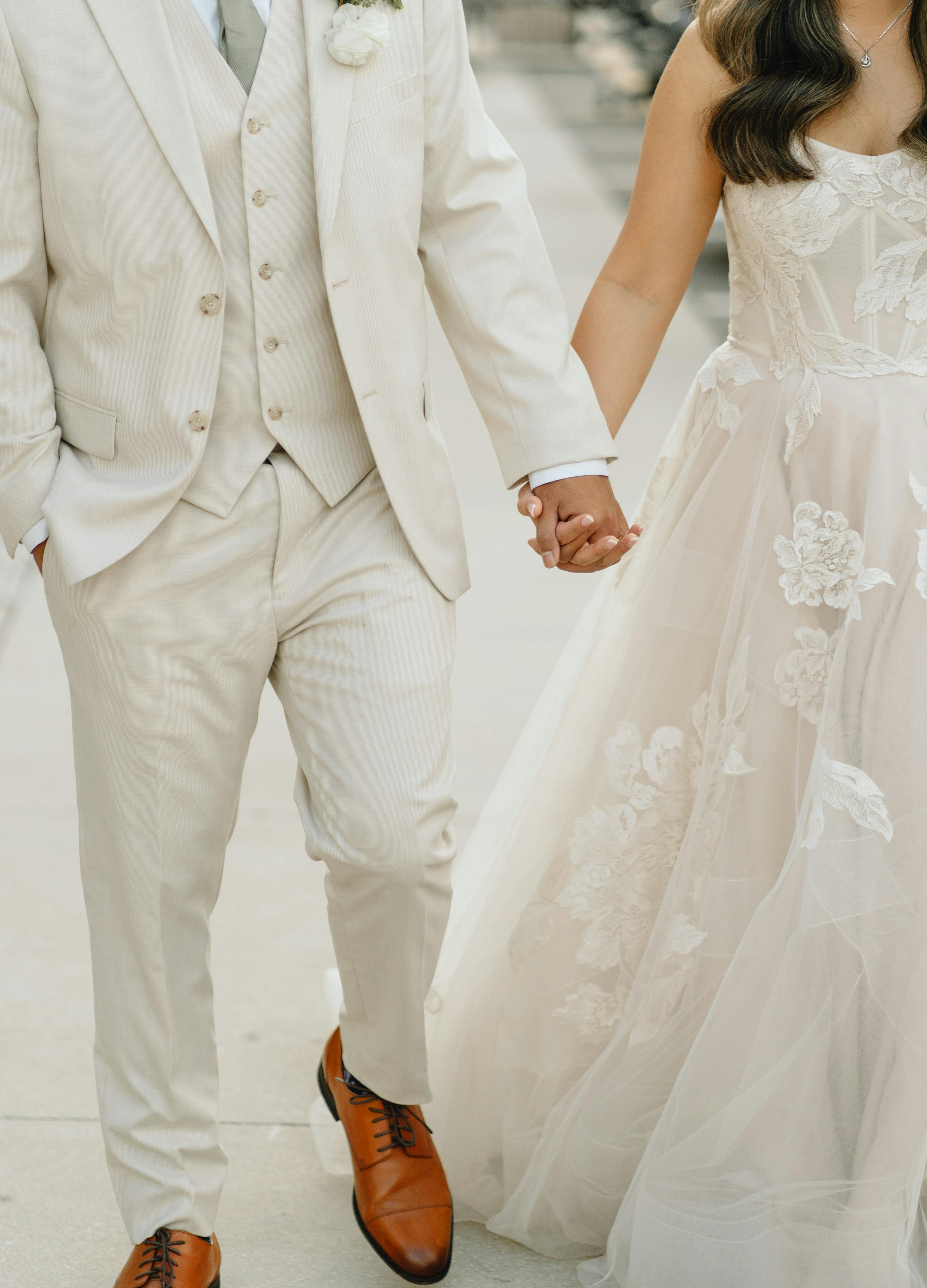 White wedding theme bridal gown with lace and men's light tan groom suit