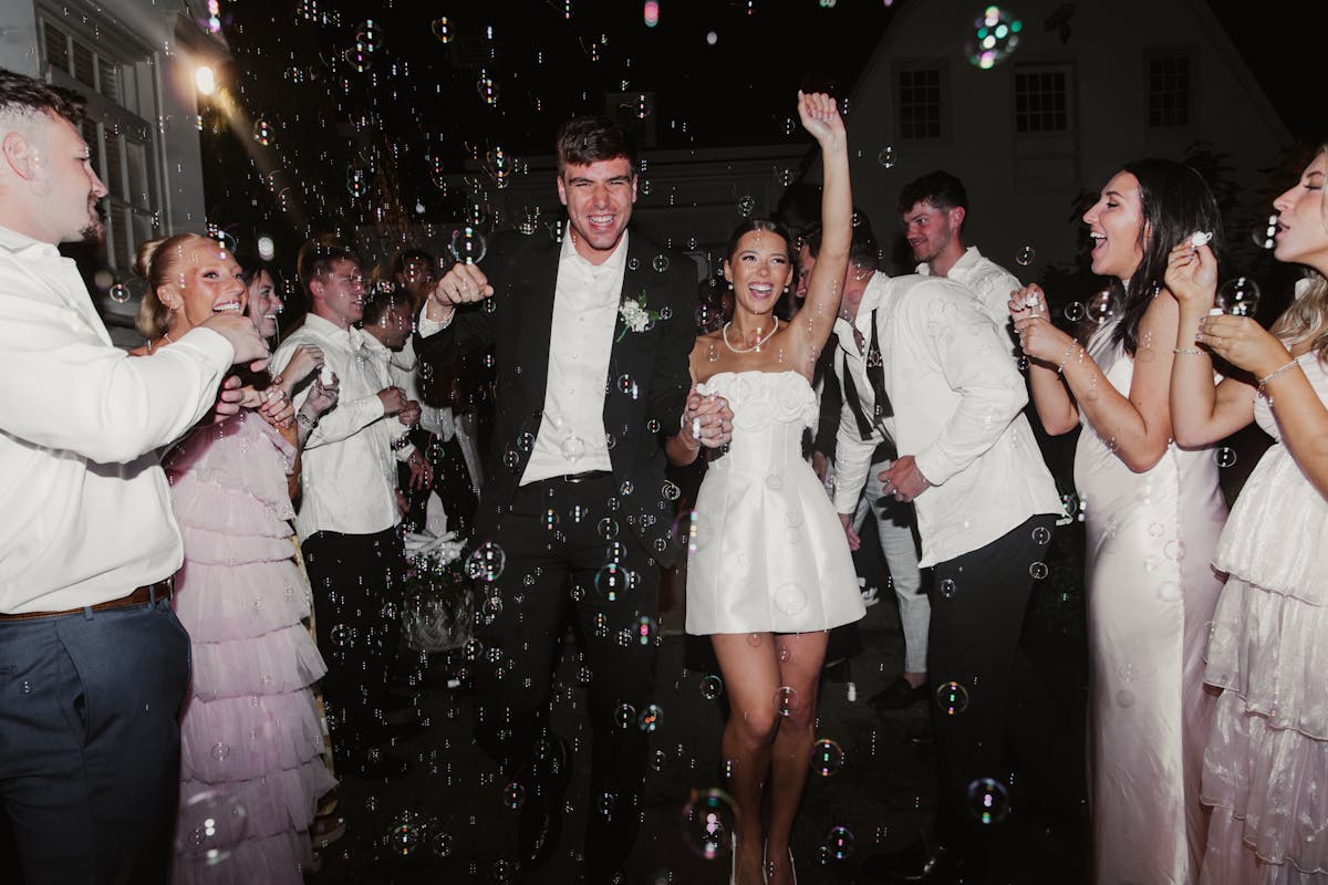 Bridal party at white color palette wedding wearing light pink and black attire