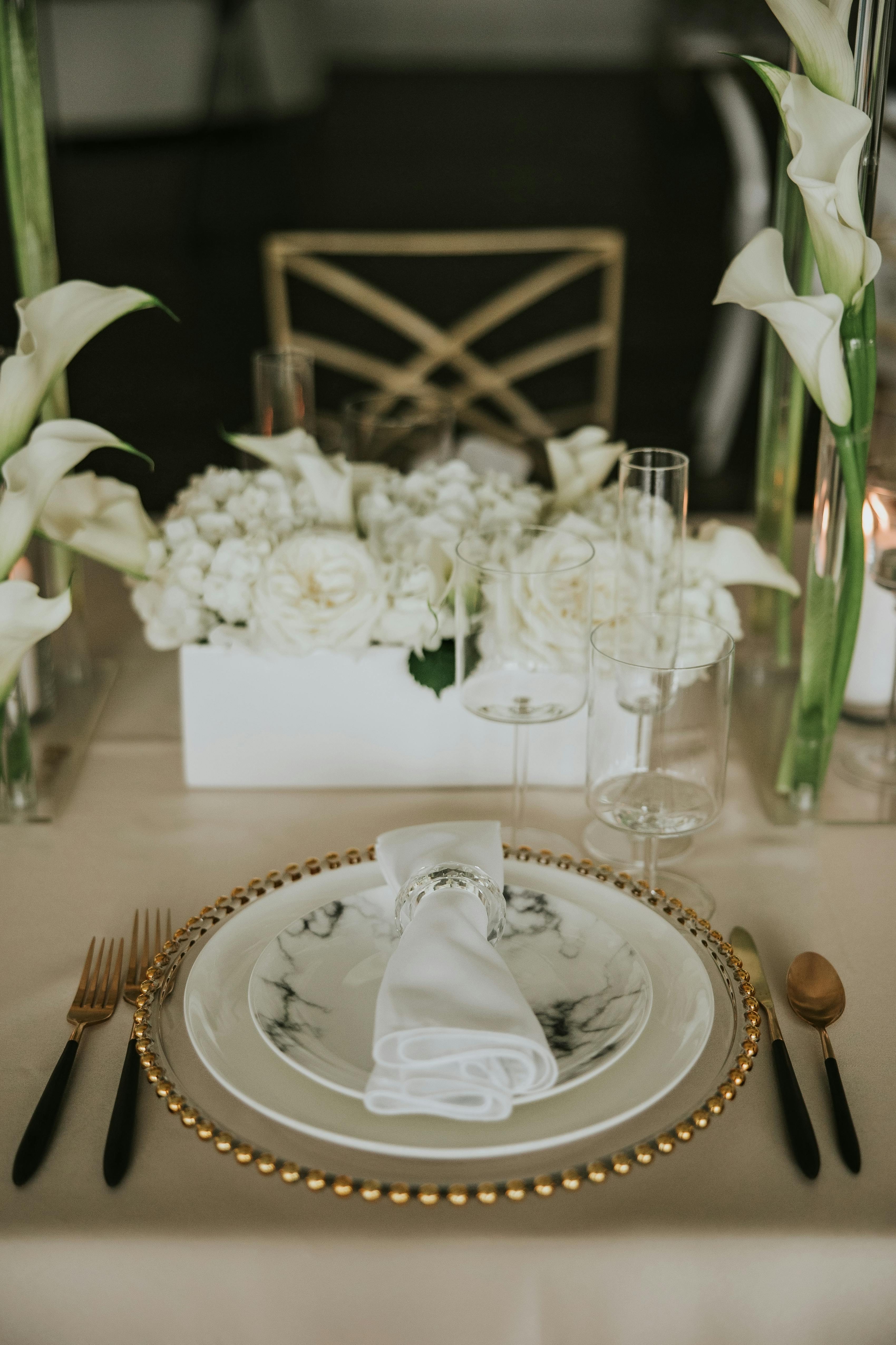 Calla lilies and place settings for white theme wedding decor