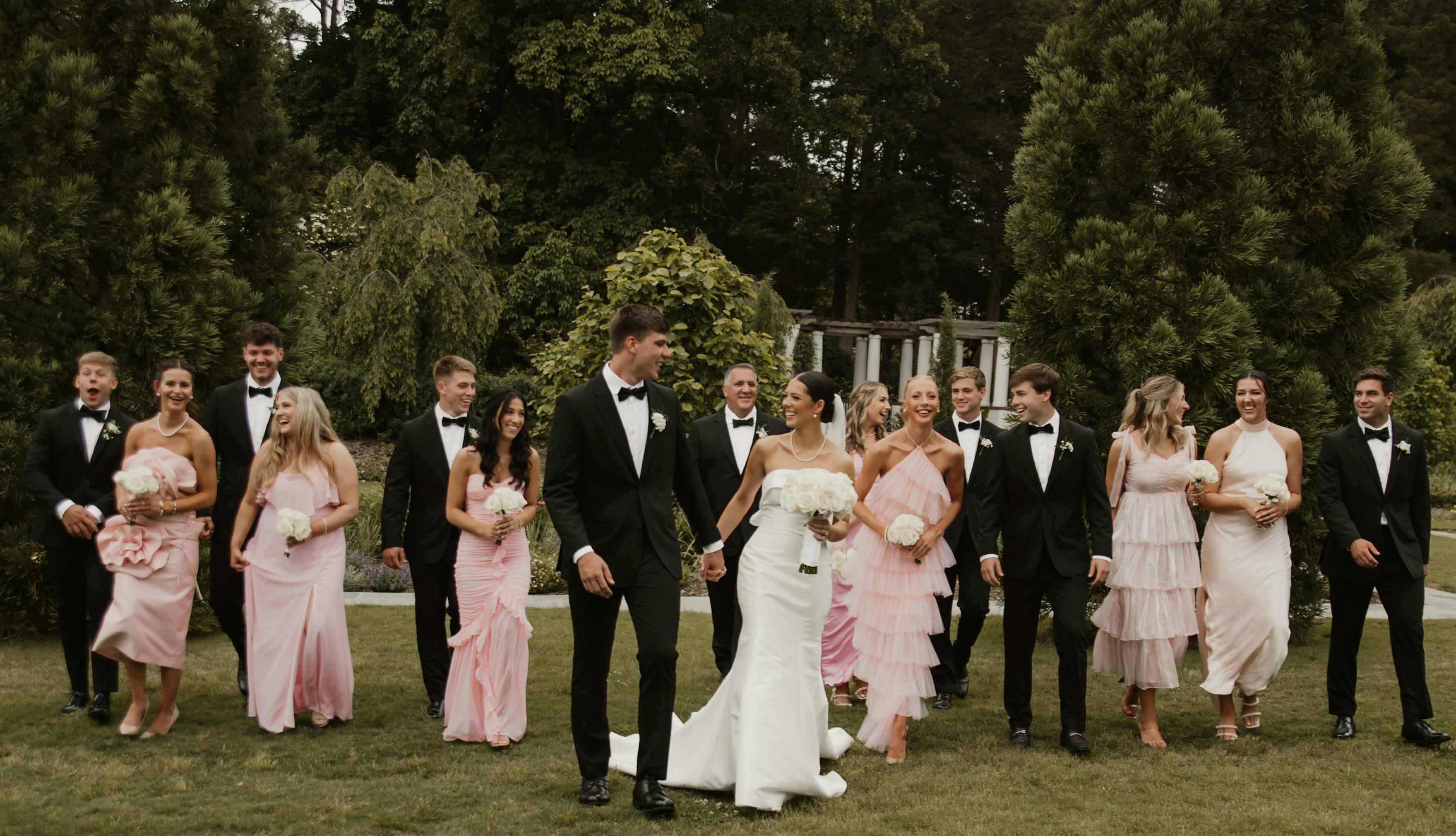 Aesthetic pink bridal party with black tie groomsmen for chic modern nuptials