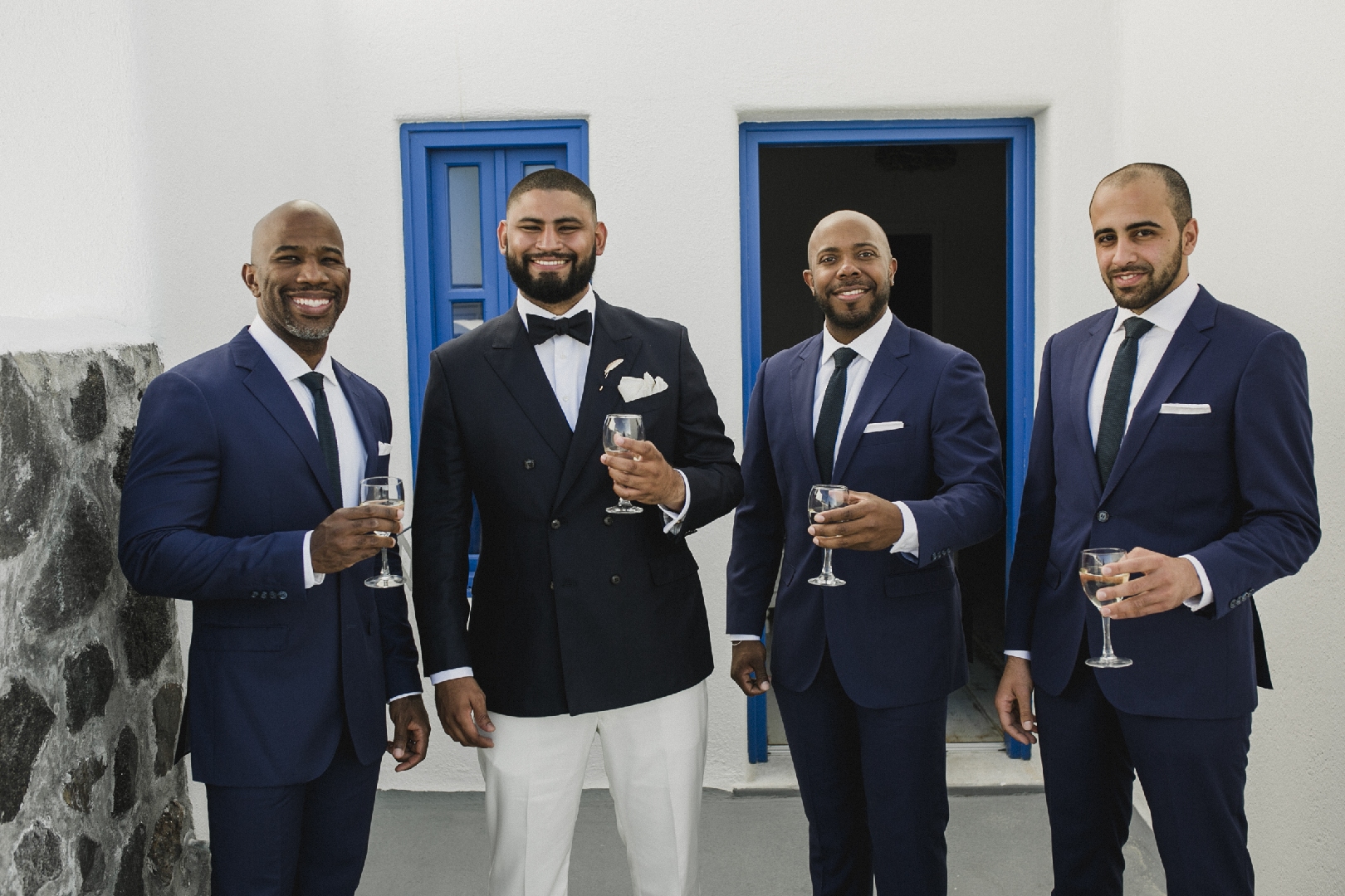Standout groom style with navy double breasted suit and groomsmen's blue suits