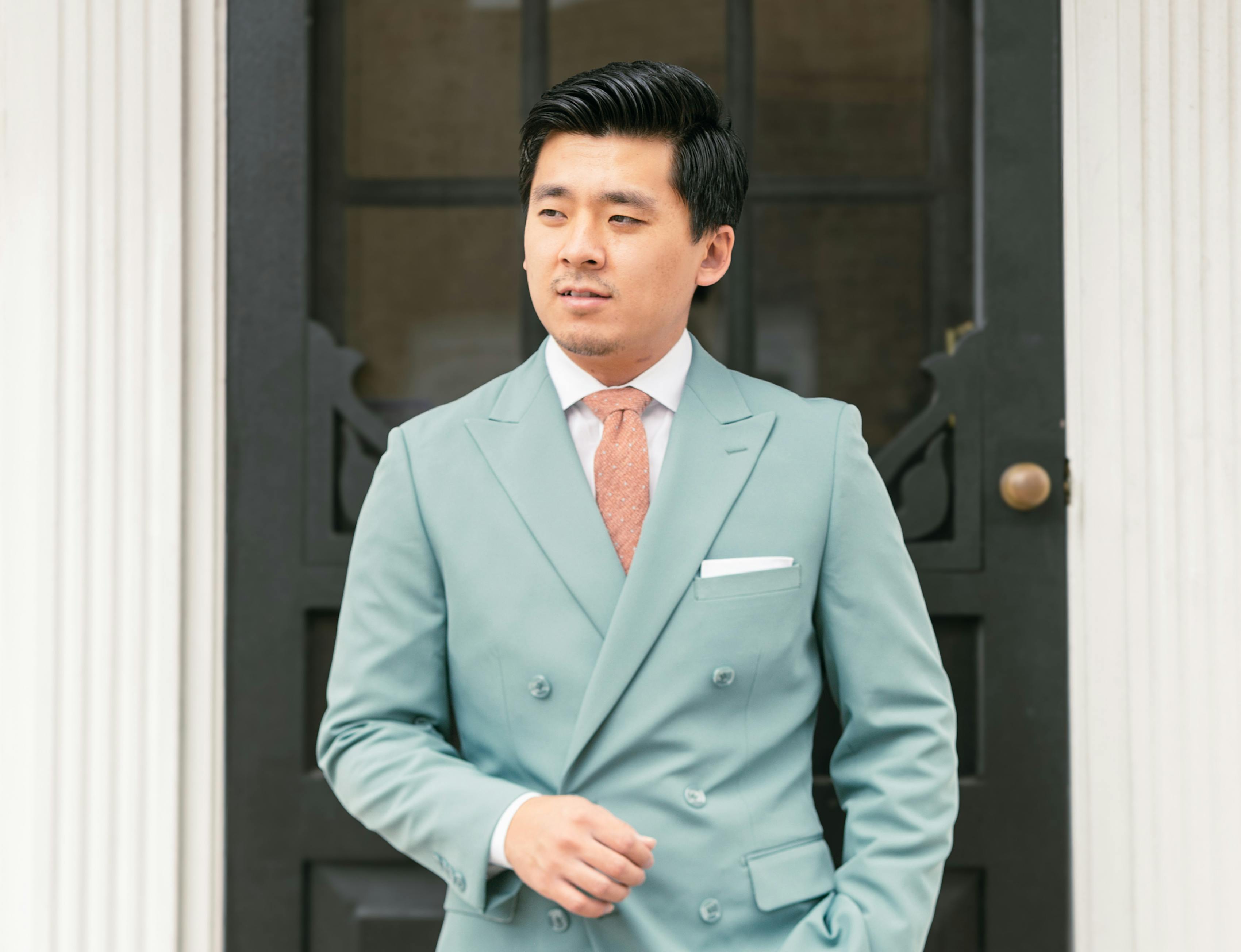 Seaglass teal suit with coral tie for colorful spring wedding