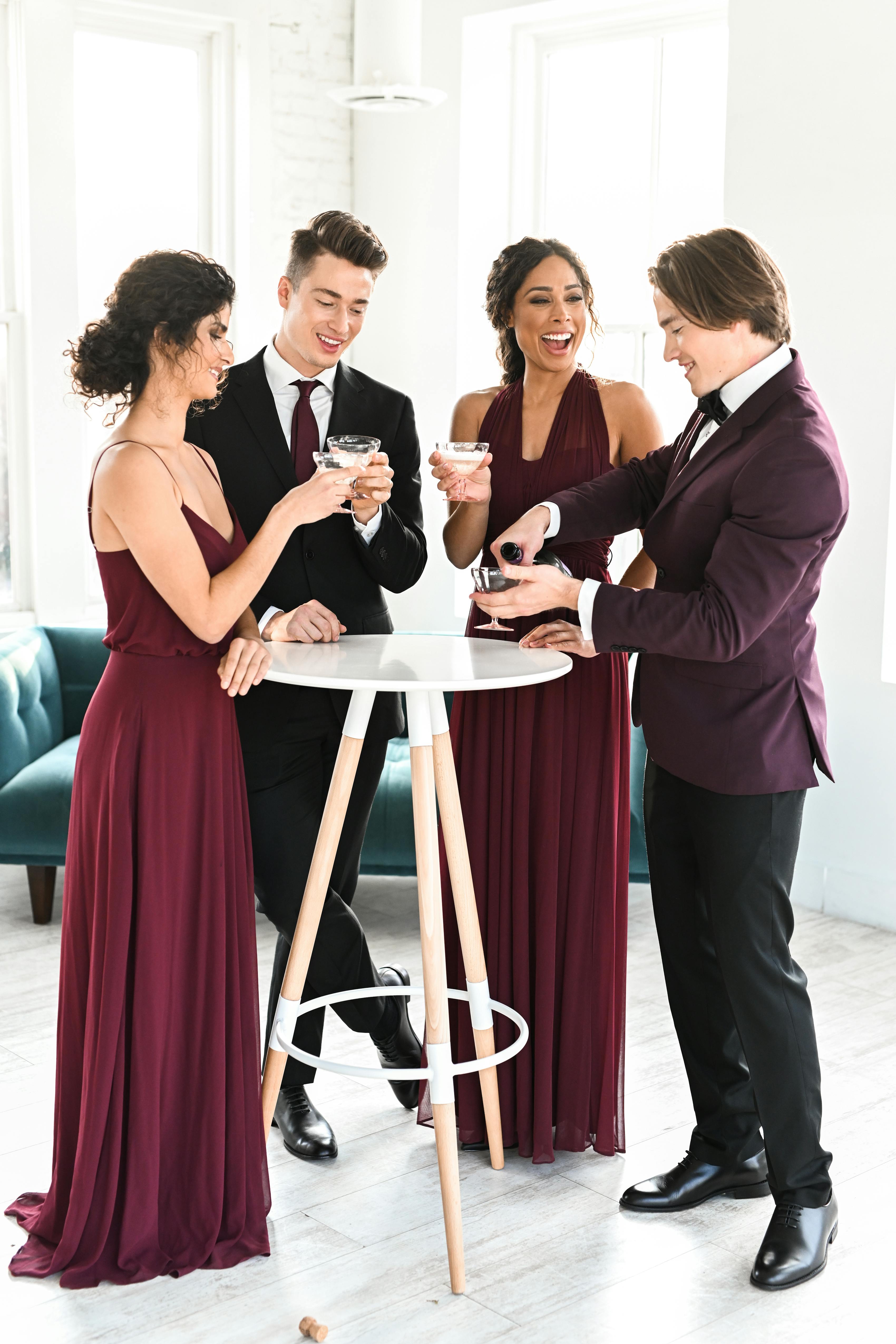Cherry red wedding guest outfits with burgundy tuxedo, maroon dresses, and black suit