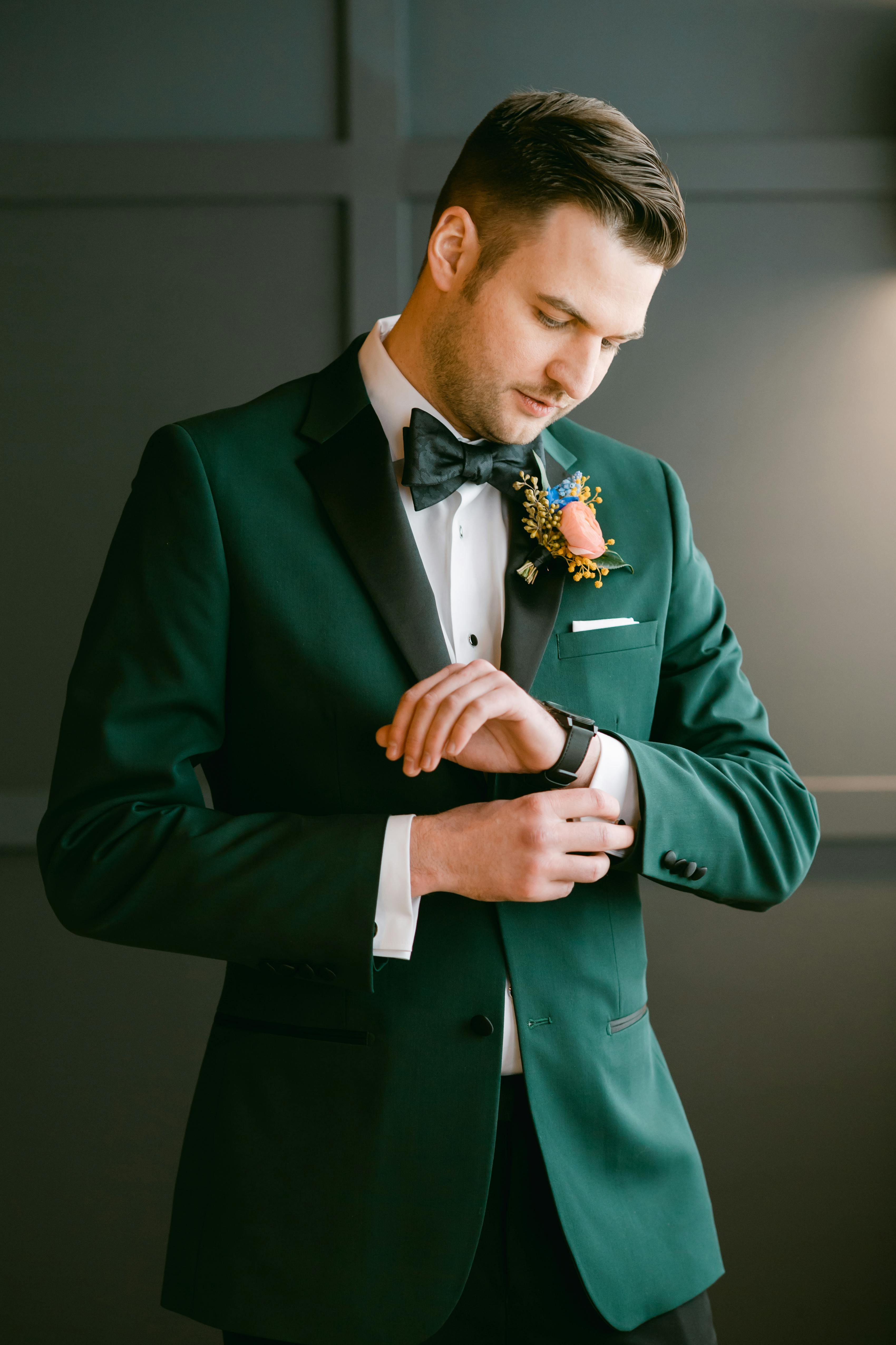 Men's green tuxedo for prom with orange boutonniere and green bow tie