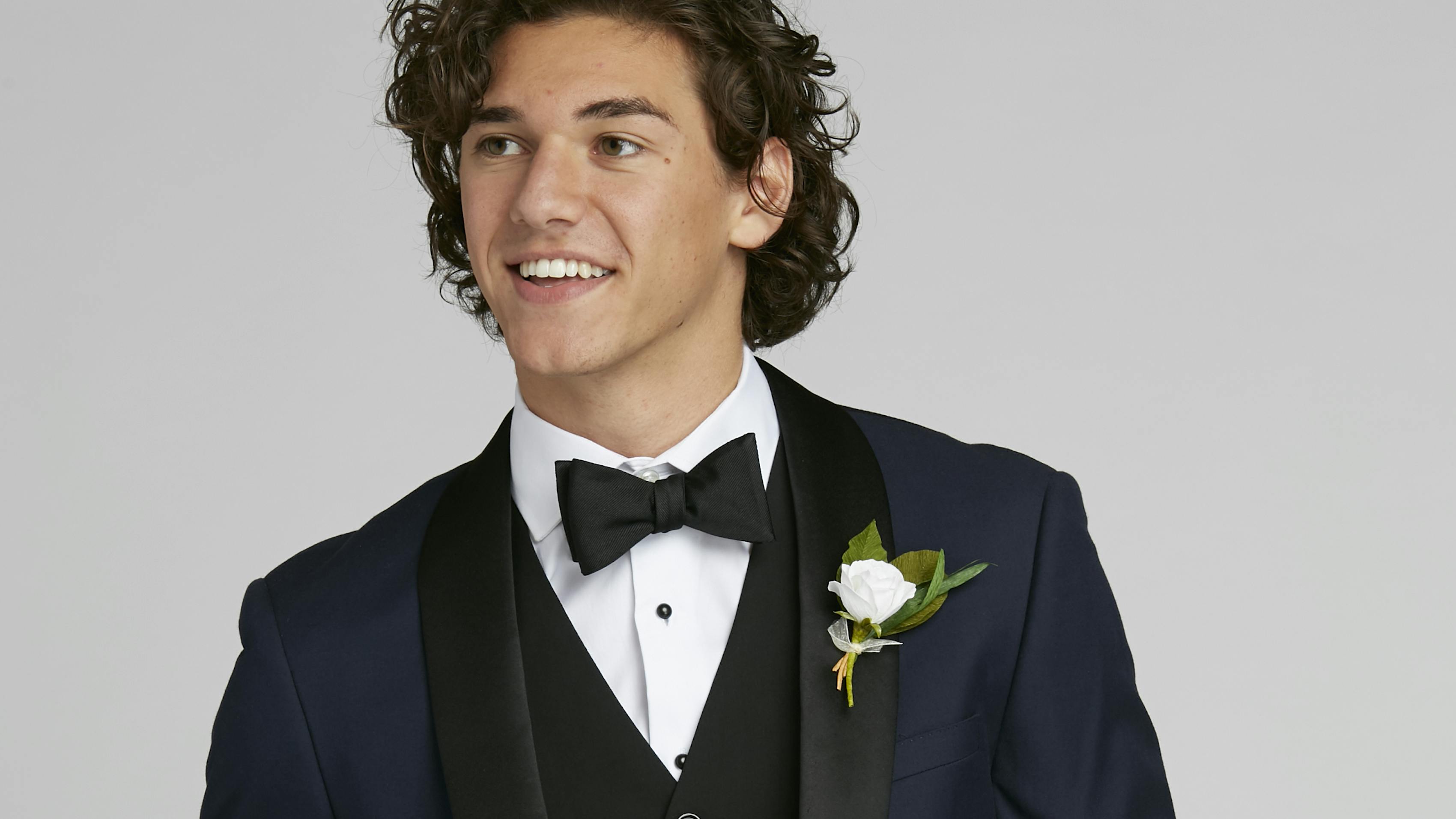 Classic guy's prom style with navy blue tuxedo with black tuxedo vest