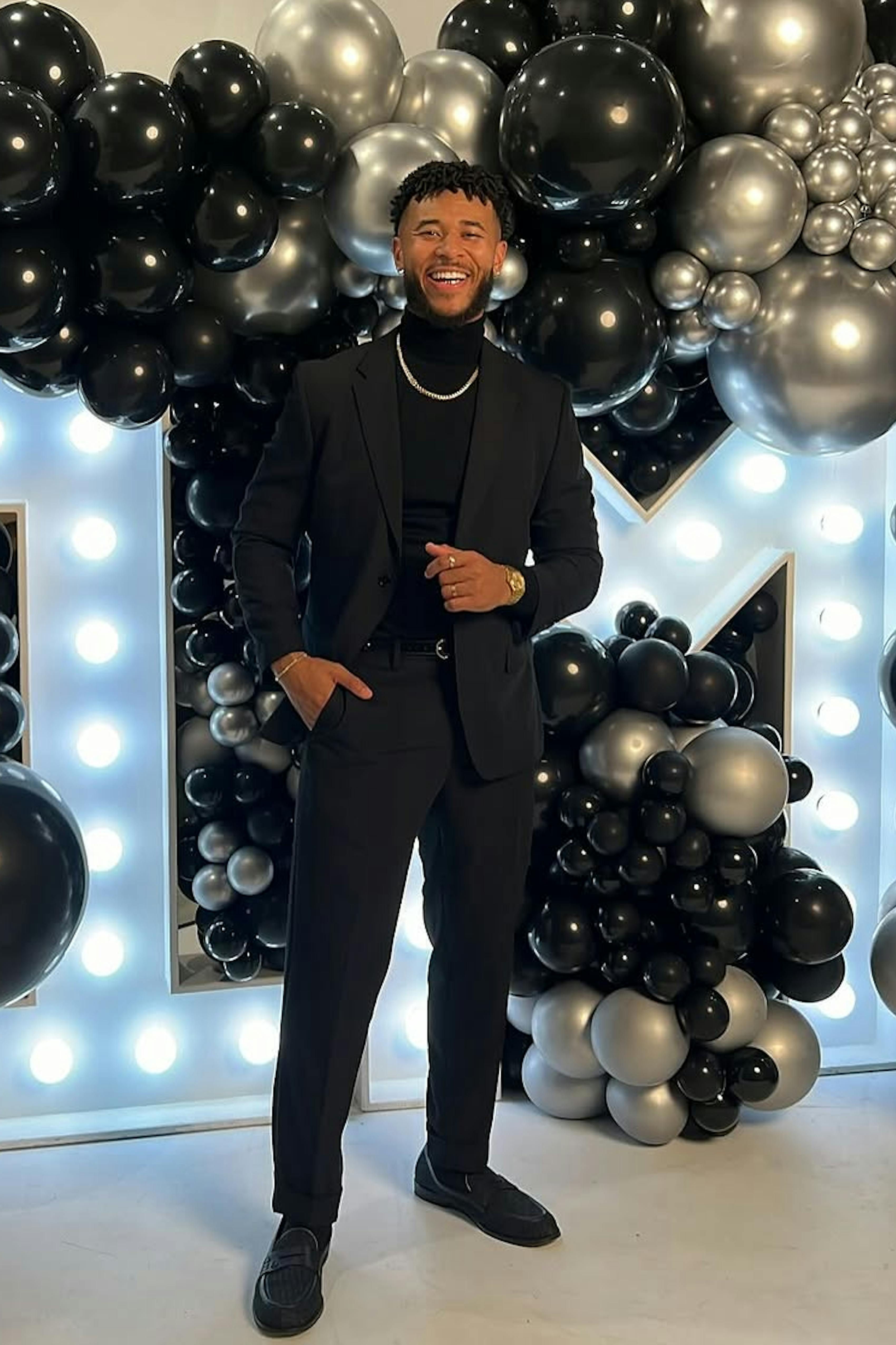 Men's black suit with black turtleneck and silver chain for men's winter formal style