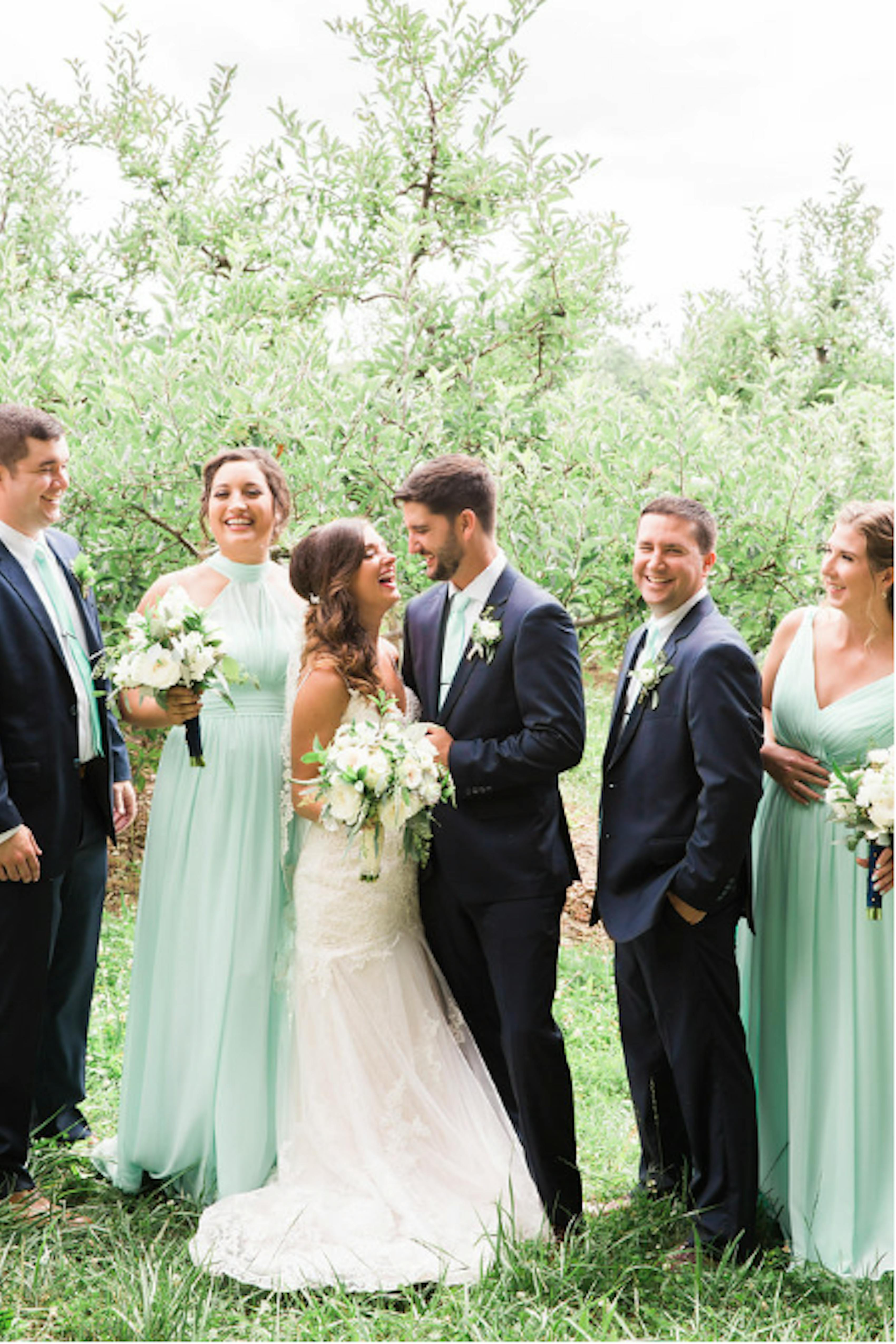 Mint green bridesmaid dresses with black groomsman tuxedos and peach wedding color accents