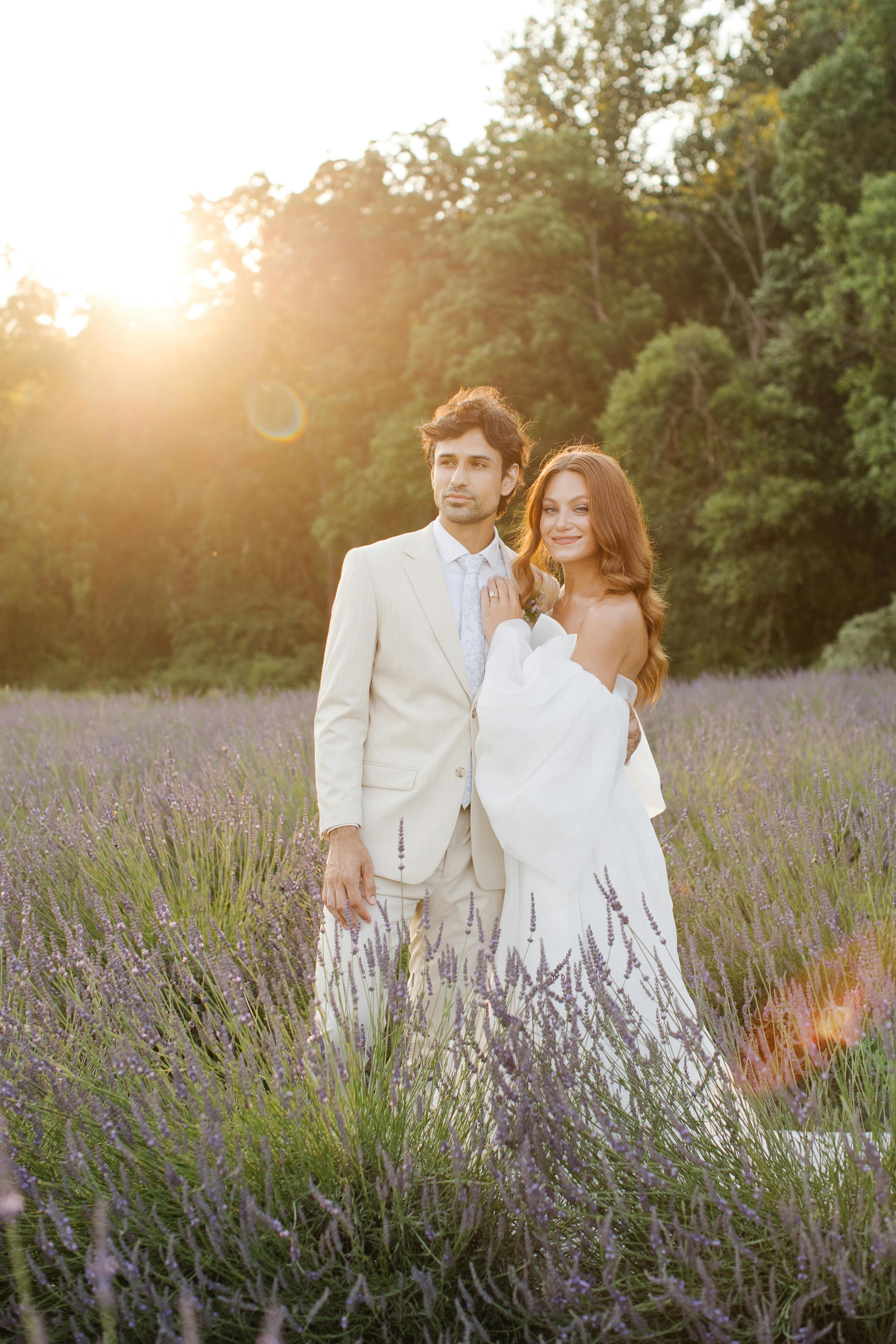 Chic bride and groom in tan suit and puff sleeve wedding dress in lavender field