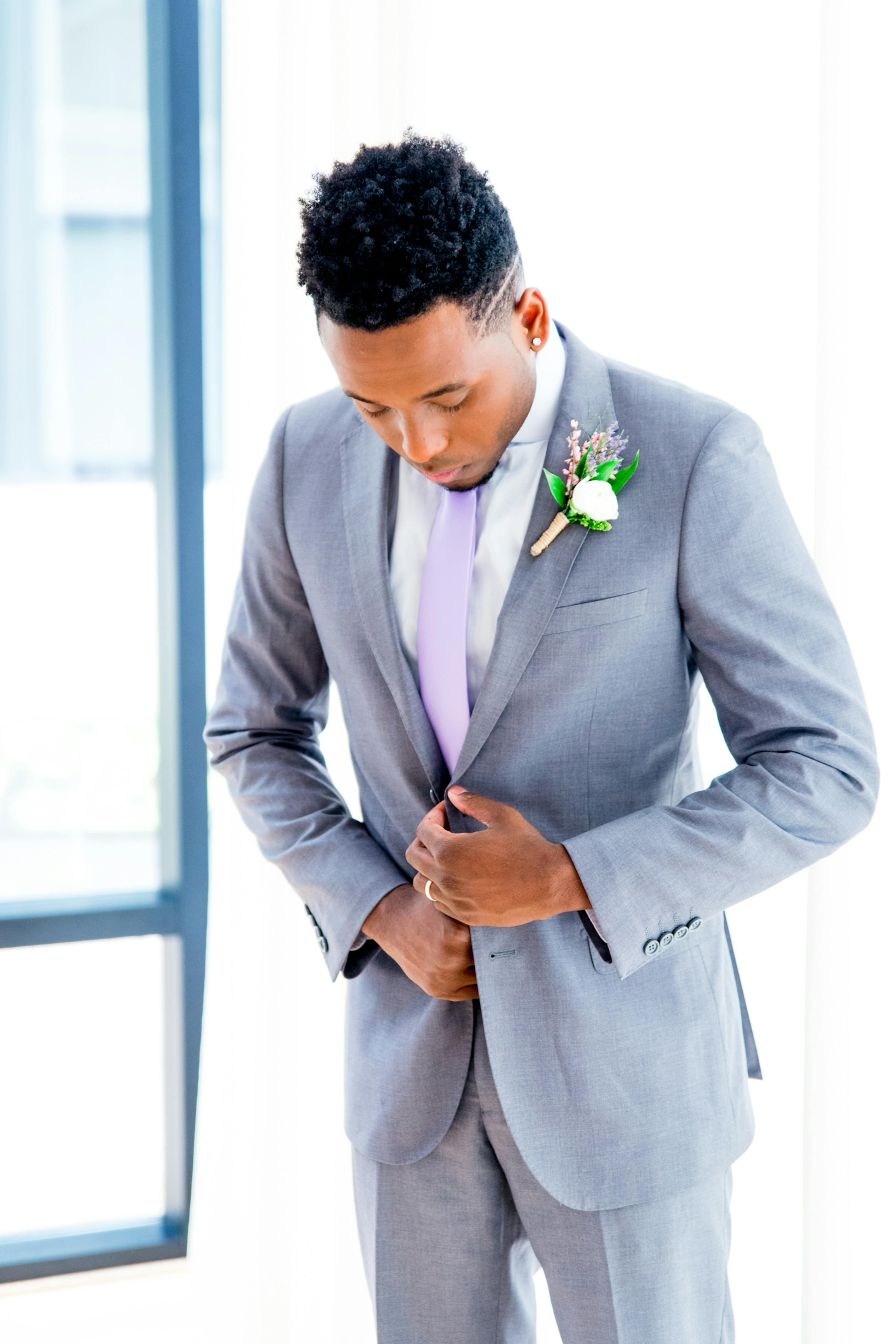 Sea glass green boutonniere with lavender tie and light grey wedding suit