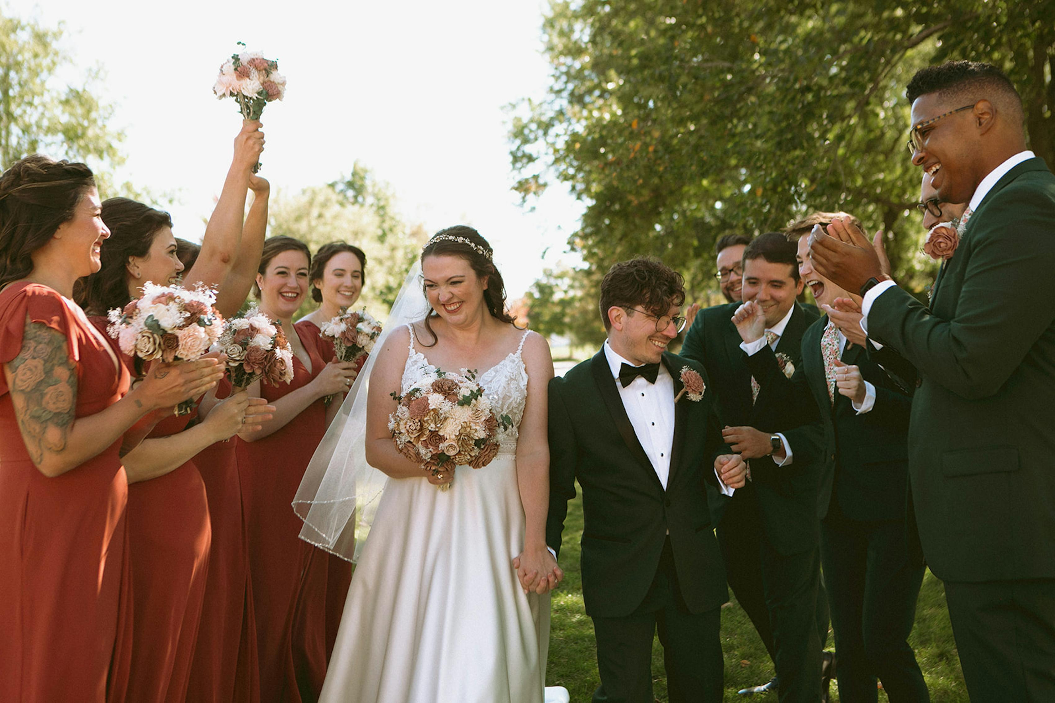 Spring wedding party in terra cotta dresses and dark olive green suits