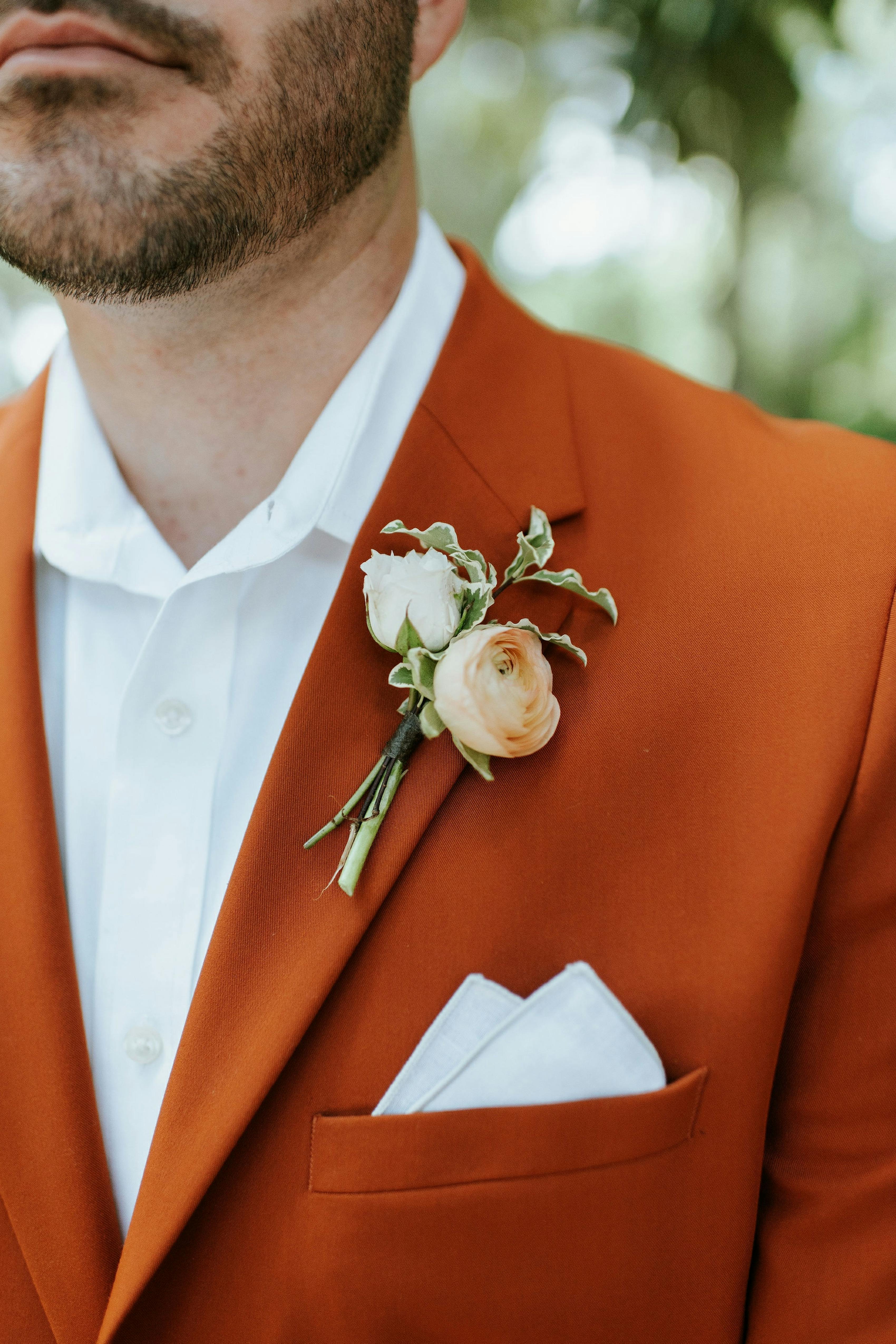 Burnt orange wedding suit with ivory pocket square for spring