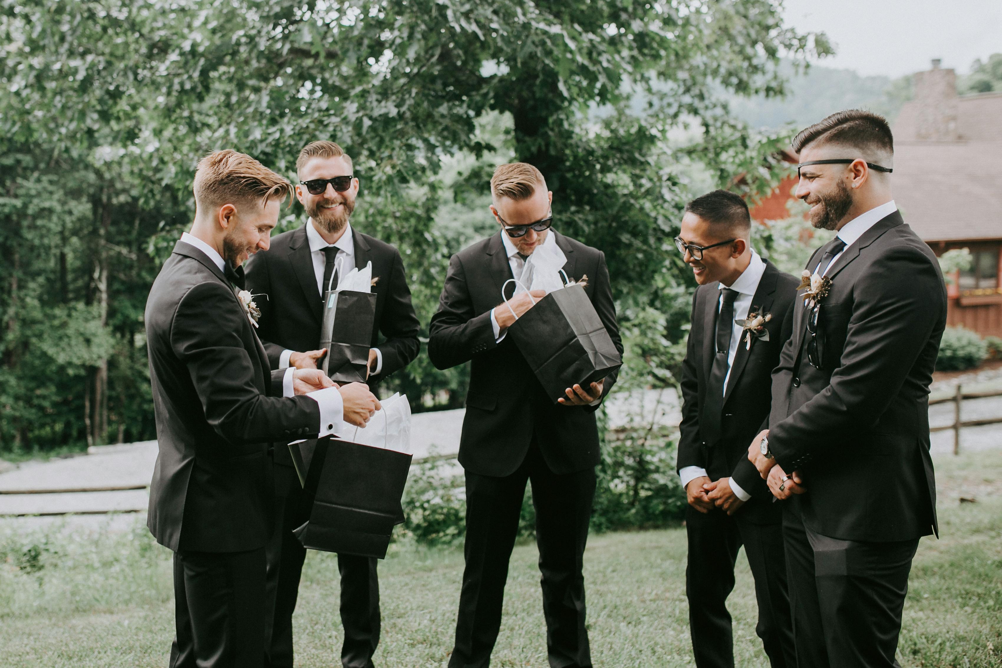 Groom handing out groomsman gifts on wedding day