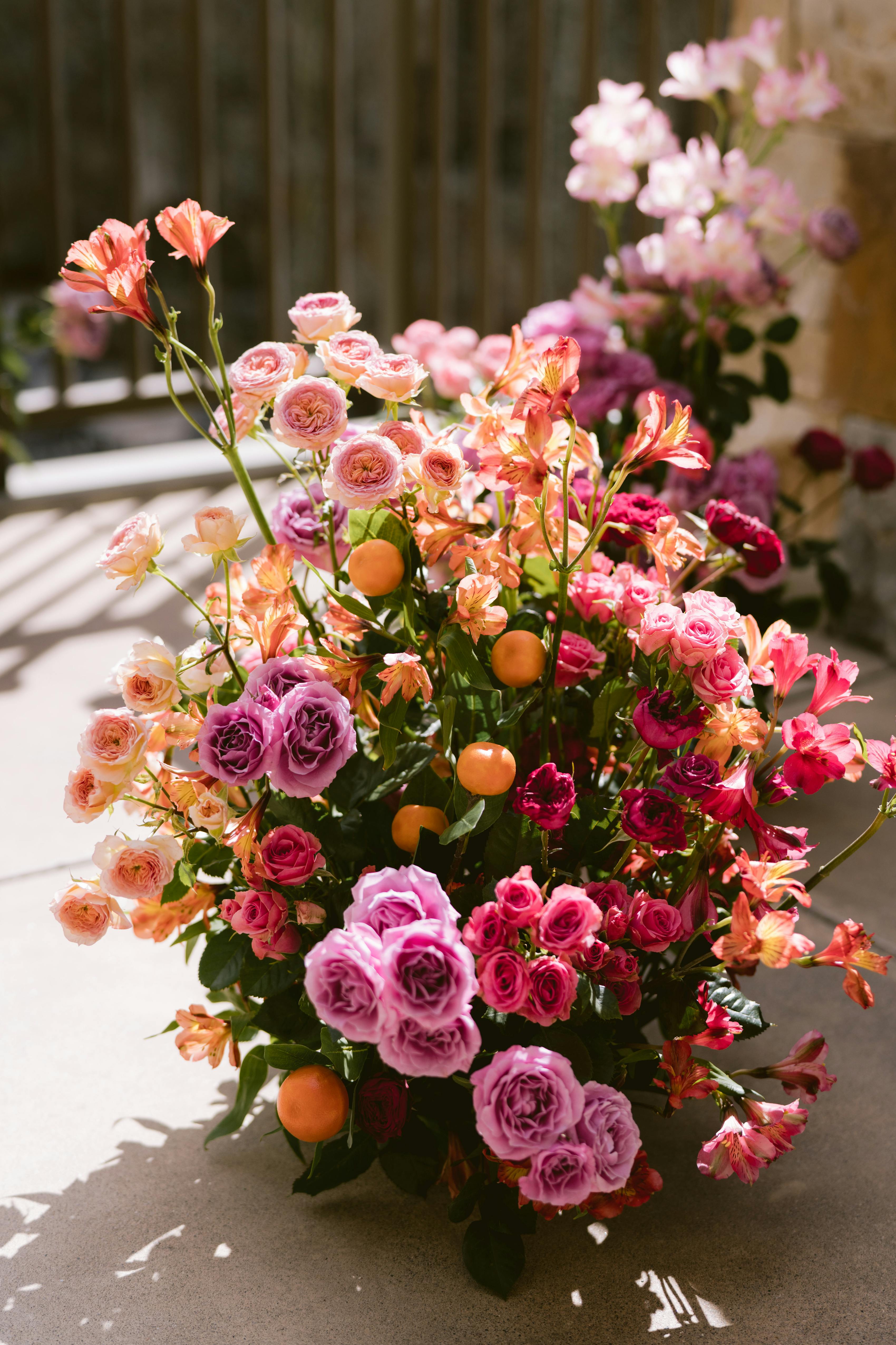 Bright orange and fuchsia pink wedding florals down the aisle