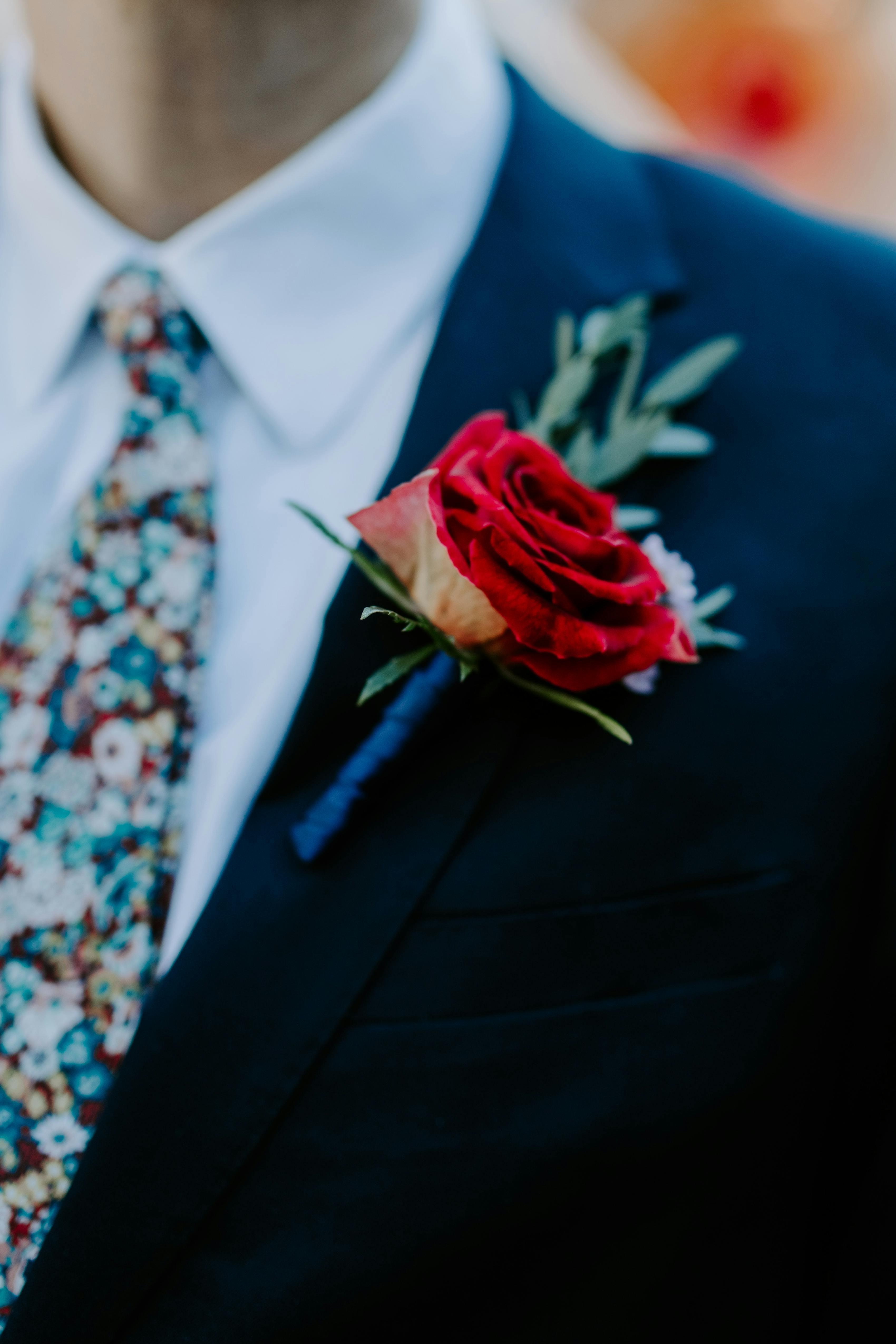 Dark teal suit with red rose boutonniere for trendy colorful wedding