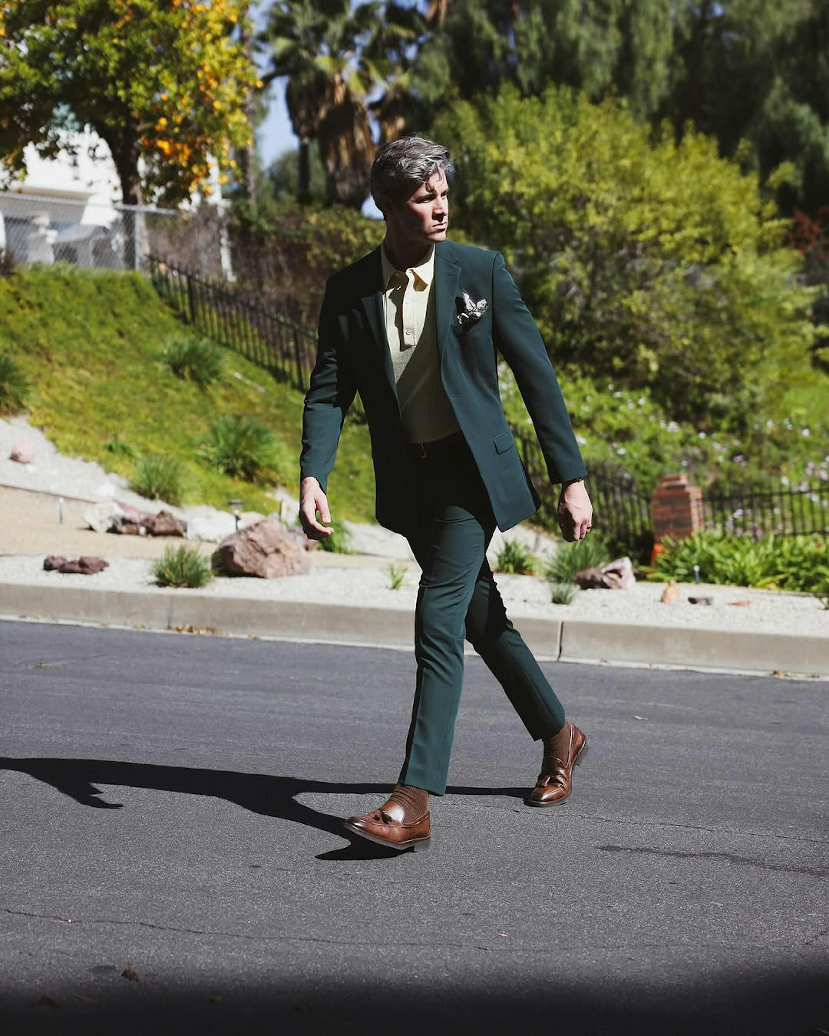 Cool guy's suit street style outfit with dark green suit and butter yellow knit polo