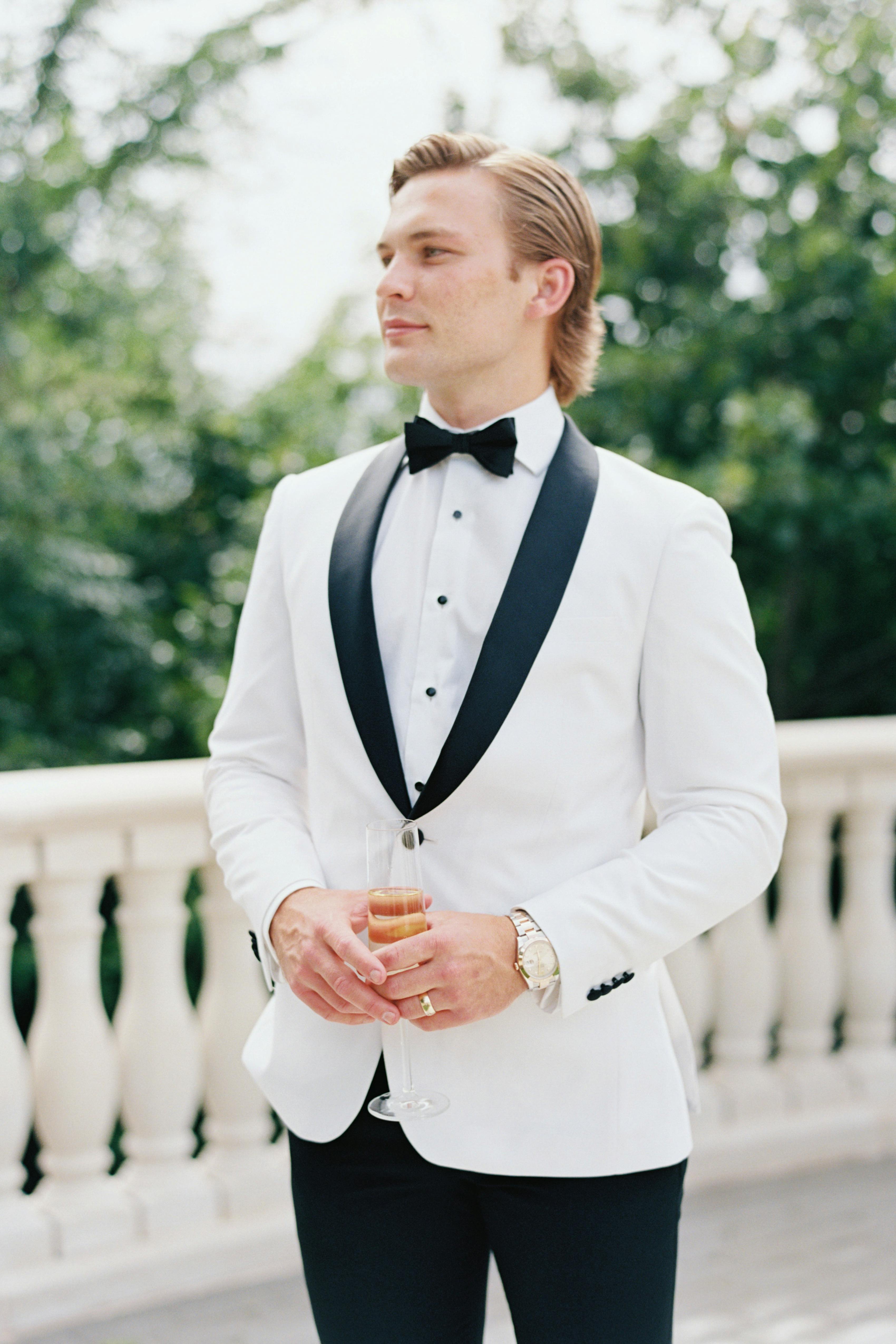 Ivory groom's tuxedo jacket with black bow tie and black tuxedo pants
