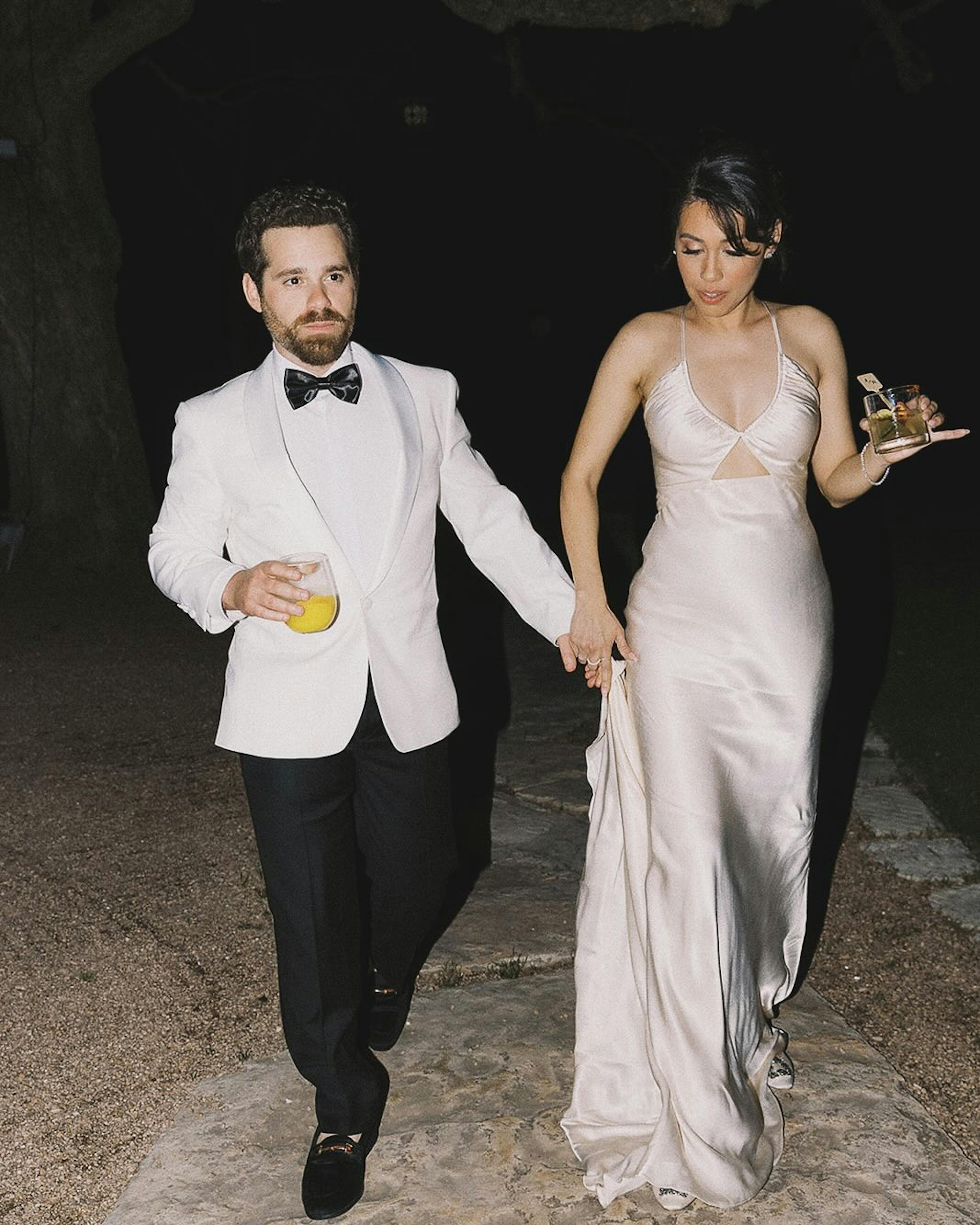Reception outfit for groom in white tuxedo jacket with black pants and silk 2nd look dress