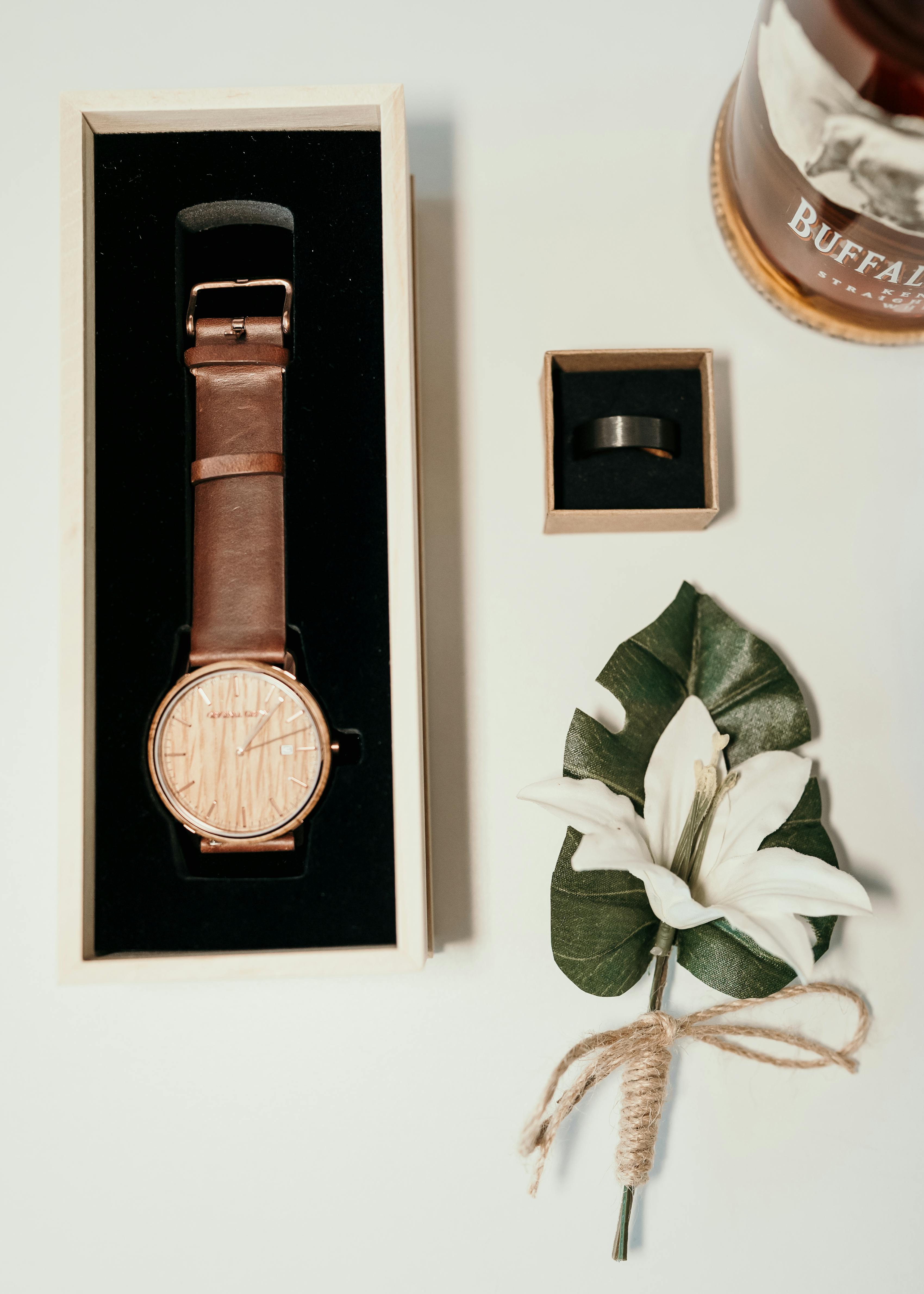 destination wedding groom accessories including leather watch and white boutonniere wrapped in twine